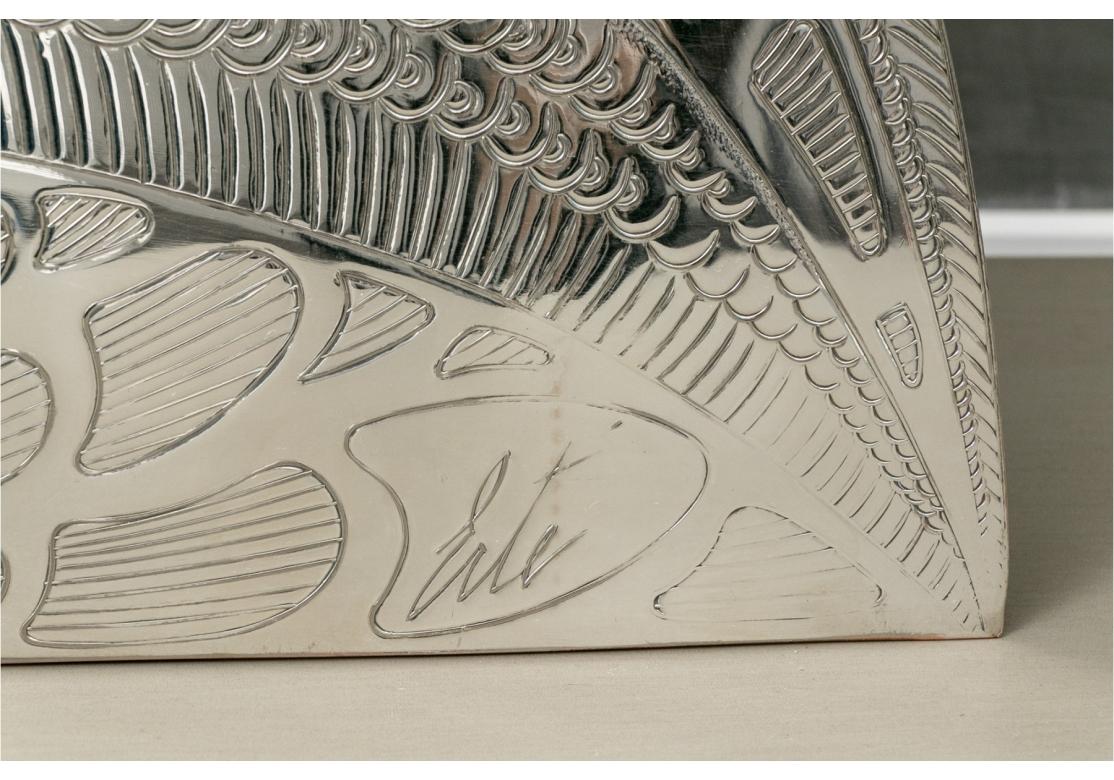 Erte peacock form silver plate serving tray comprised of two intertwined birds with elaborate detail in a demilune form. The tray with lower gadrooned trim is resting on three ball feet. Comes with hanger for display.
Impressed Erte lower right.
