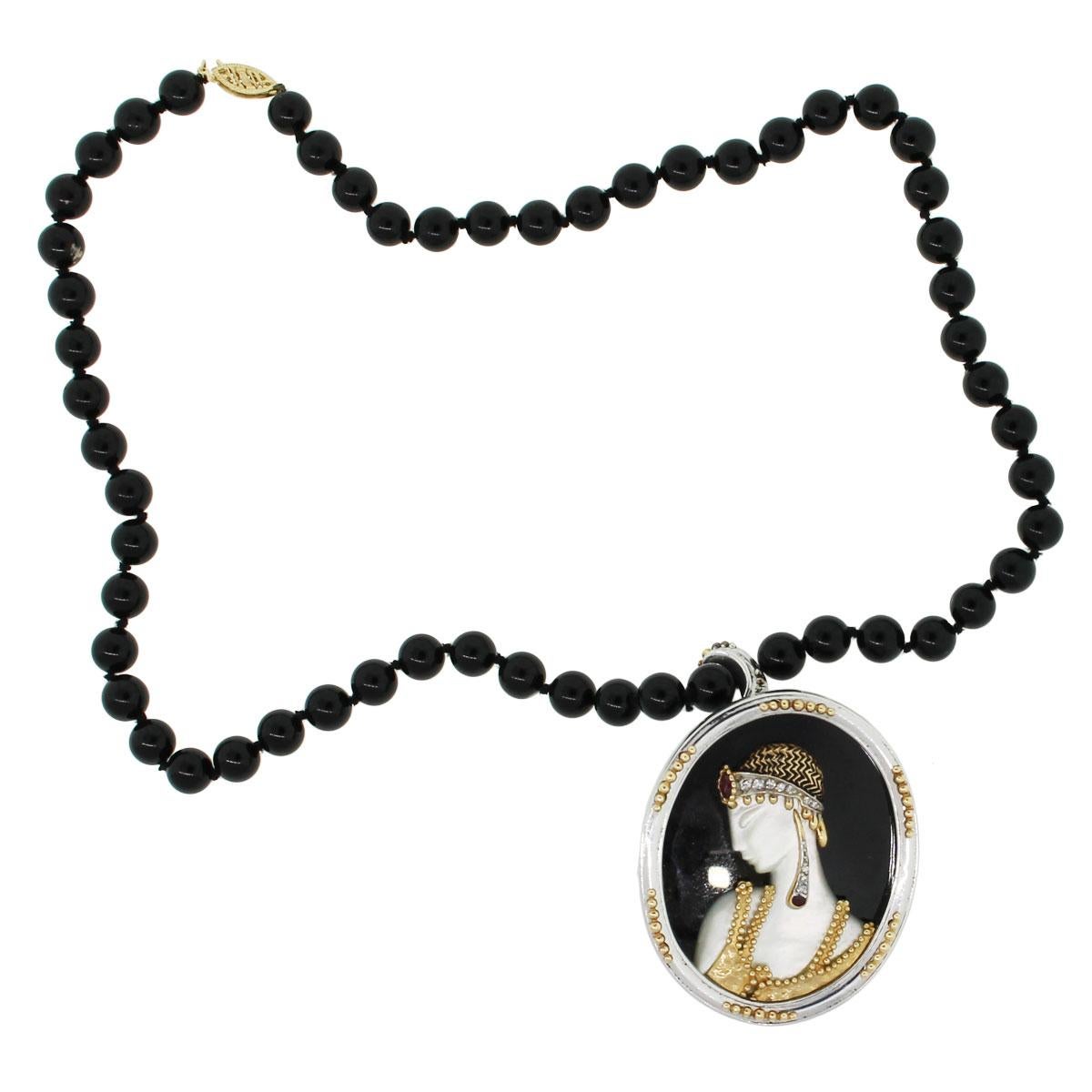 Designer: Erte
Material: 14k white gold and sterling silver
Gemstone Details: Onyx beads measuring approx. 7.40mm in diameter. Woman silhouette is made from Mother of Pearl
Diamond Details: Approximately 0.08ctw of round brilliant diamonds
Necklace
