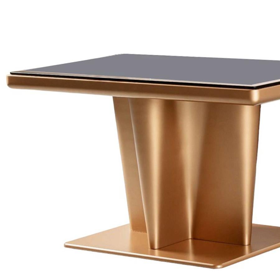 Table basse Erwan avec structure en acier inoxydable
en finition bronze avec un plateau en verre smocké.