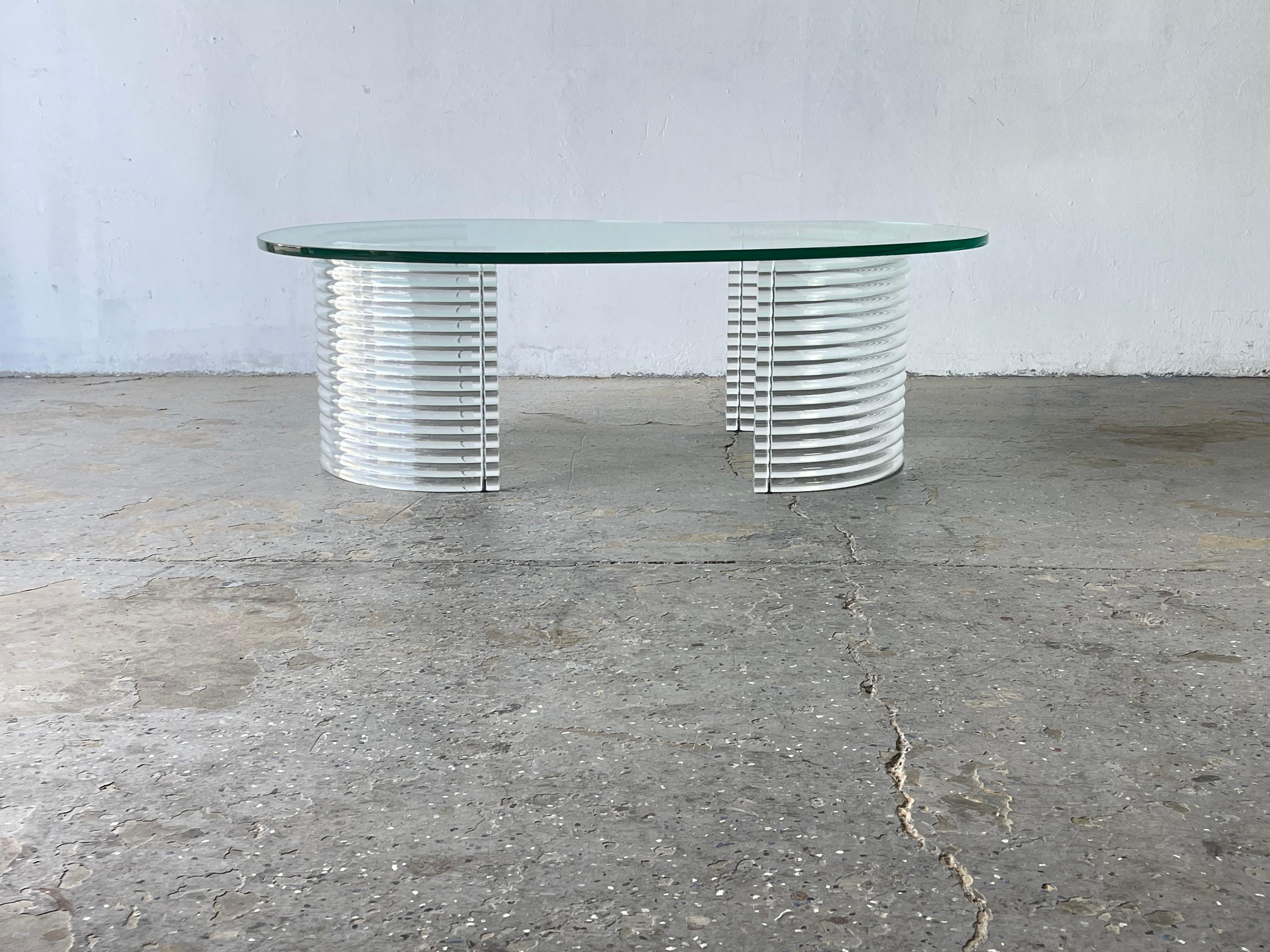 1980s, Postmodern Lucite and Glass Coffee Table 

 Unique vintage coffee table with two lucite / acrylic “U shaped” bases. 1 inch thick  beveled,Kidney shapes  glass rests on top. It’s light and airy and very cool. 

Possibly attributed to Erwin &