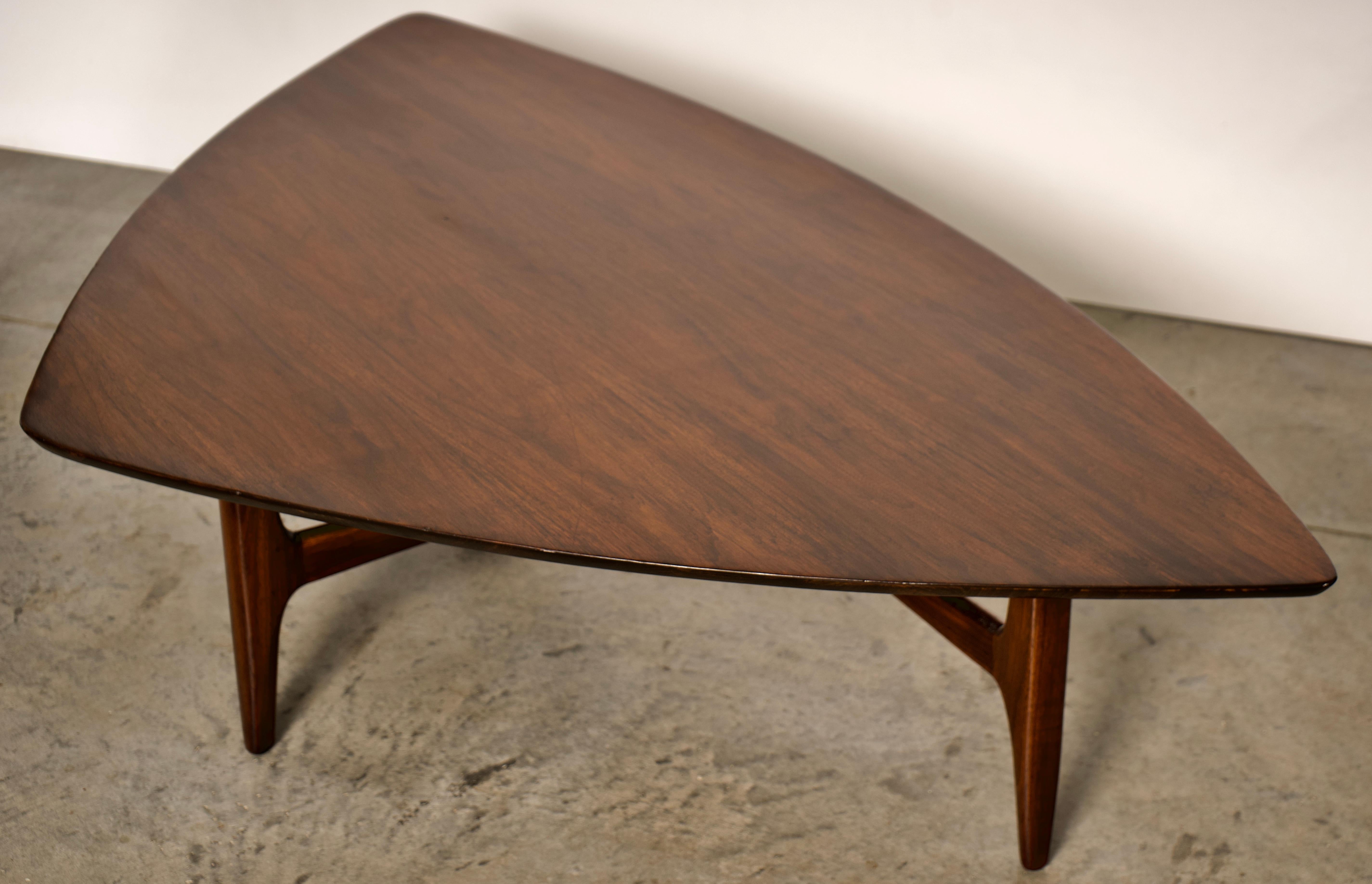 Erwin Lambeth Mid-Century Modern triangle coffee table. American 1960s modern designer coffee table by Erwin Lambeth in fantastic, original condition. The table is crafted out of solid walnut wood and glistens in a high-gloss finish.

Erwin