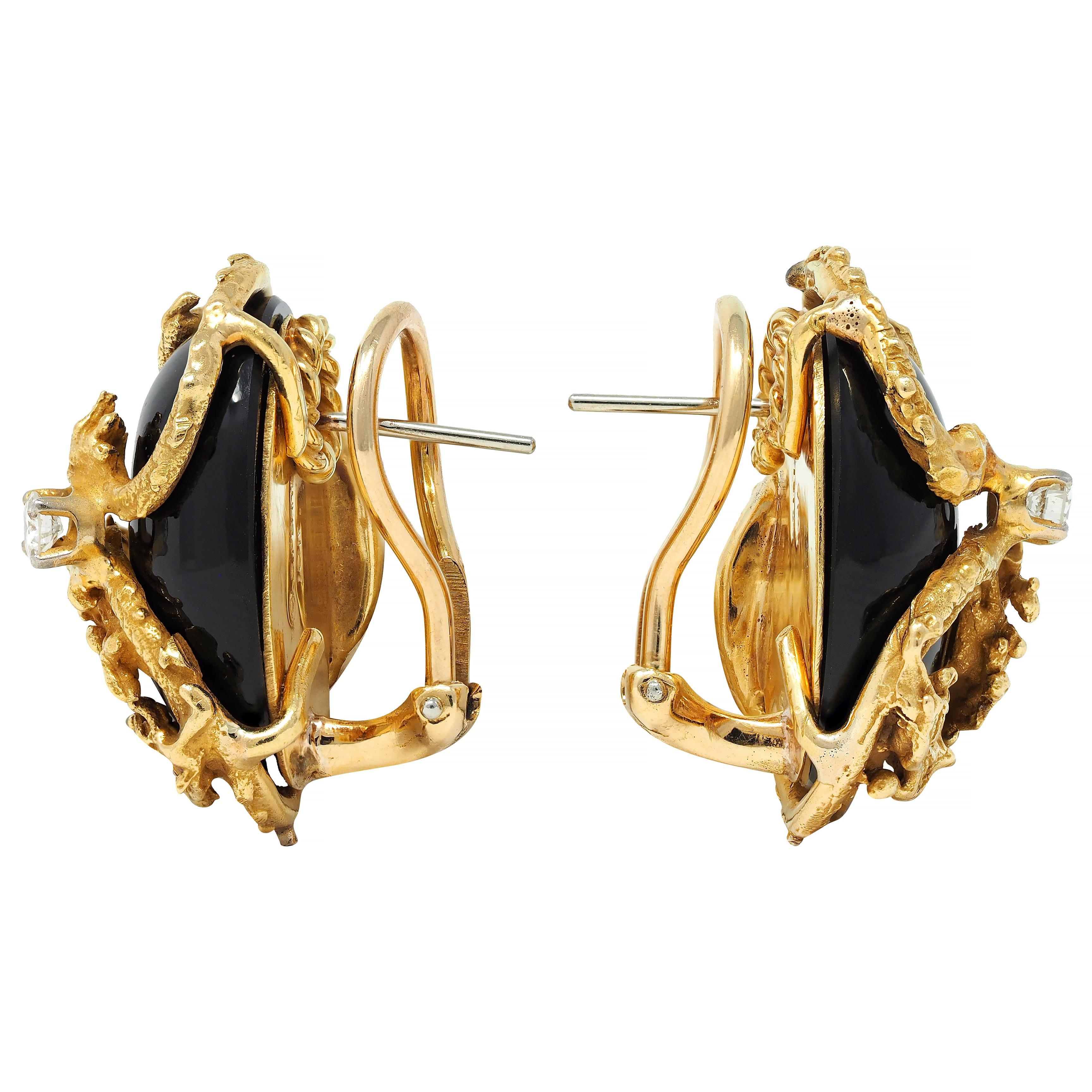 Featuring oval-shaped onyx cabochons measuring 15.0 x 20.0 mm 
Opaque glossy black with a highly rendered gold dragon surround
Swirled round onyx with engraved scales and brutalist features
Accented by prong set transitional cut diamonds 
Weighing