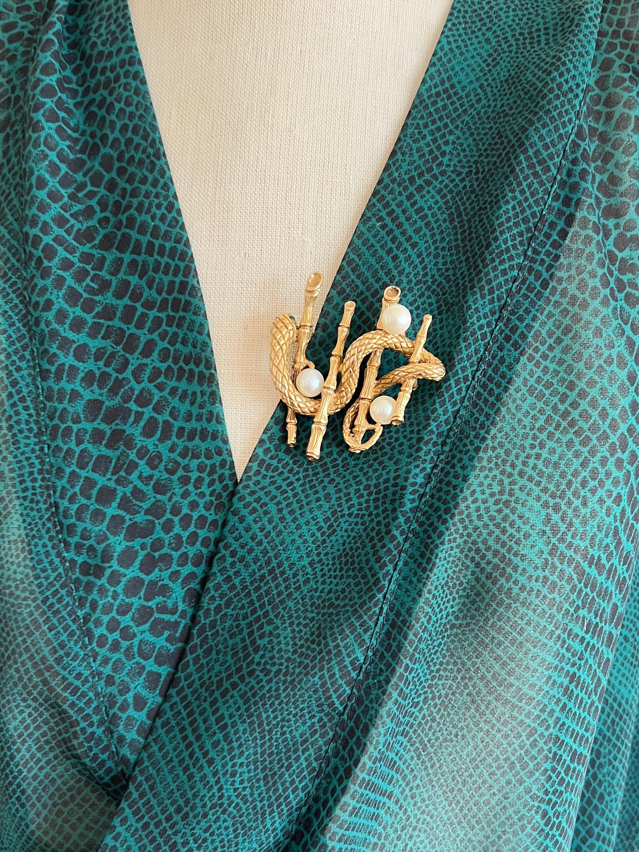 Este broche es una pieza vintage de Erwin Pearl, con un intrincado diseño de serpiente envuelta en motivos de bambú, con el cuerpo de la serpiente adornado con perlas de imitación. Este llamativo diseño combina la elegancia inspirada en la