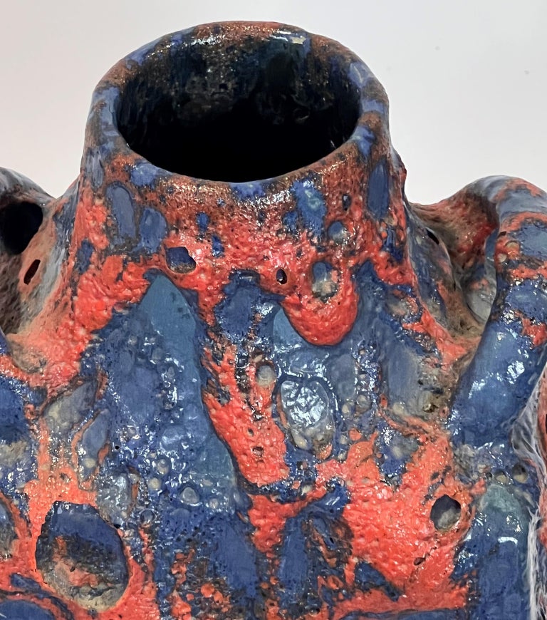 A gorgeous blue and read fat lava vase from ES Keramik Emons & Sohne. The blue ranges toward periwinkle and the depth of glaze and dripping burst overlayer of red is attention grabbing! Dating this is an imprecise art, but the firm closed in the