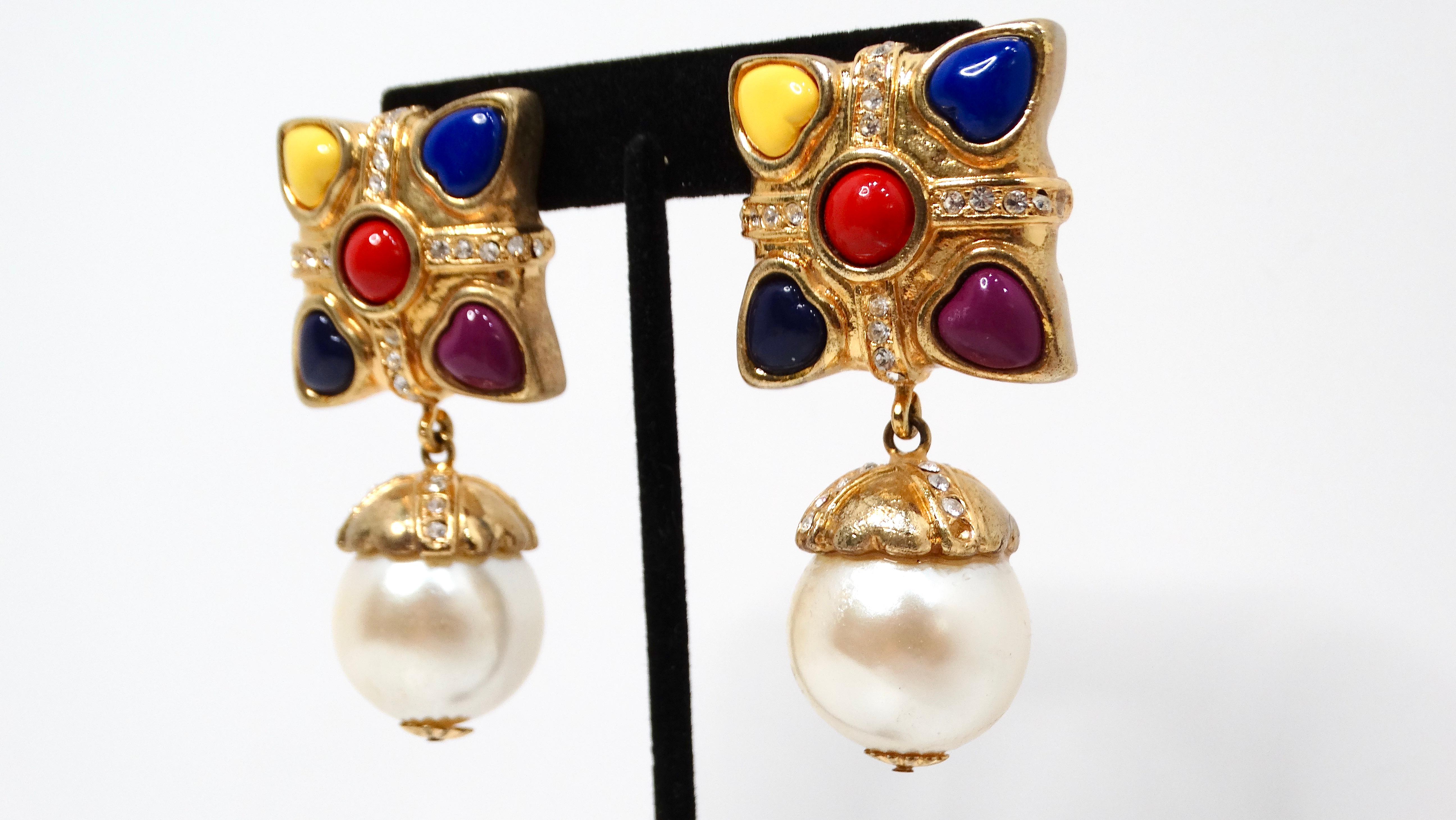 Add a touch of whimsy and elegance to your jewelry collection with the Escada 1990s Multicolor Hearts & Pearl Drop Gold-Tone Clip-On Earrings. These unique earrings feature a striking square design crafted from radiant gold-tone metal, showcasing an