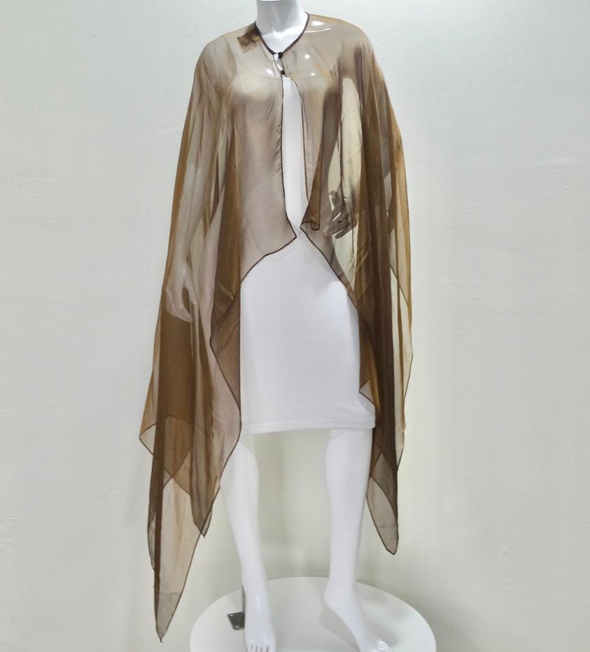 Do not miss out on this breath taking and rare Esacada Couture 100% silk cape! Your next favorite accessory is calling your name! Get a look at this gorgeous neutral brown chiffon fabric with metallic hints that glisten when it catches the light.