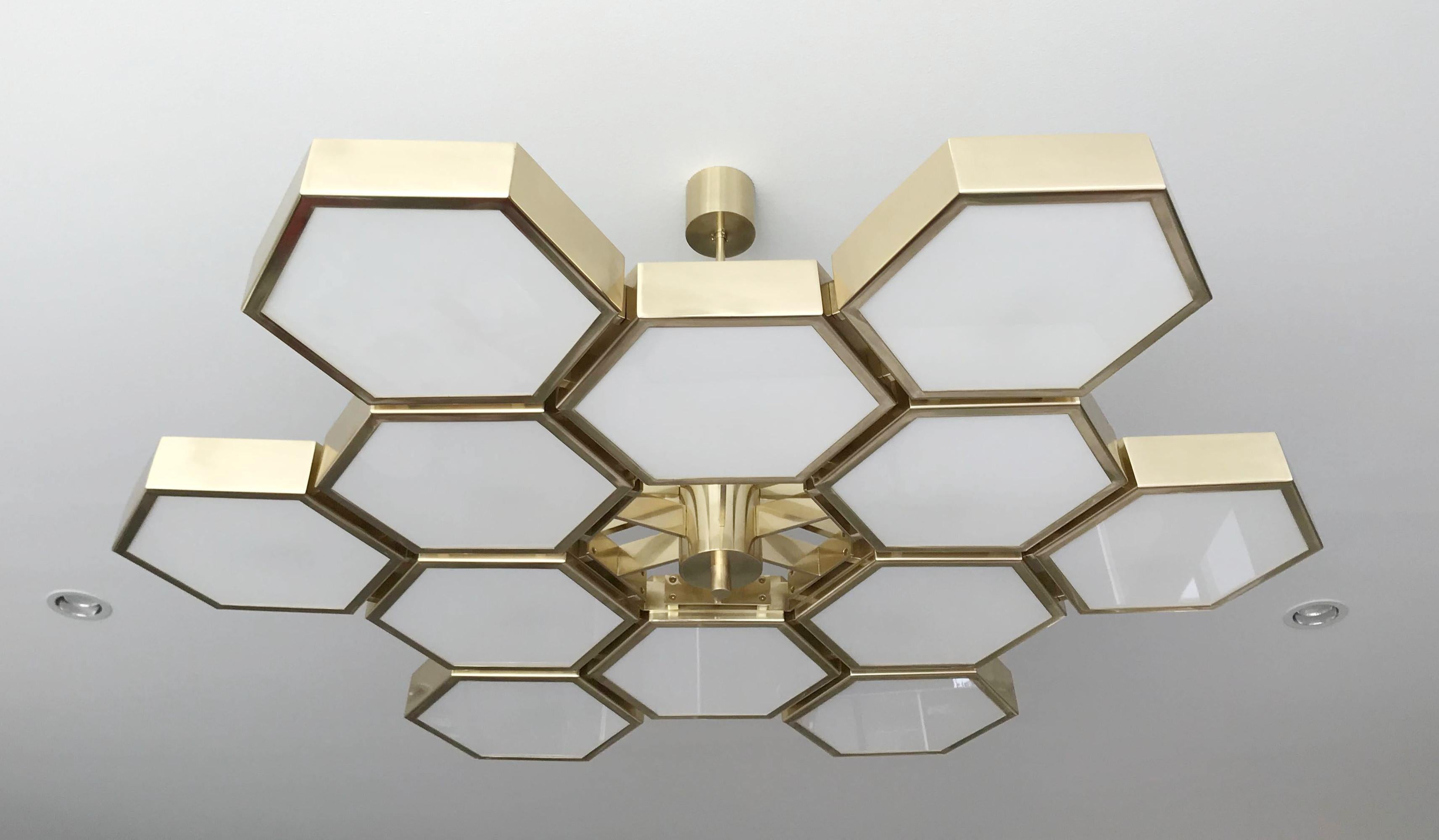 Imponente lampadario italiano con 12 diffusori esagonali in vetro bianco lucido, montati su spesse celle esagonali in ottone con finitura laccata naturale, disegnato da Fabio Bergomi per Fabio Ltd, made in Italy
12 luci / tipo E12 o E14 / max 40W