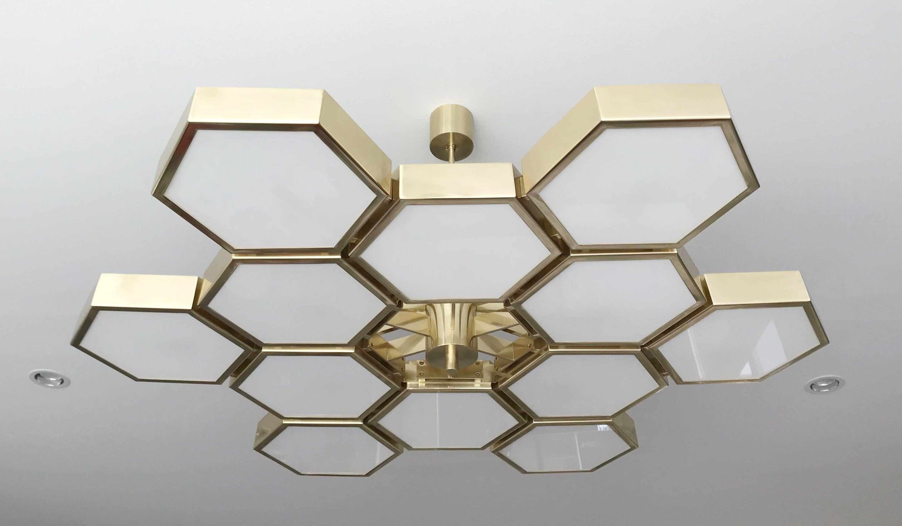 Impressive Italian chandelier with 12 hexagonal glossy white glass diffusers, mounted on thick hexagonal brass cells in natural lacquered finish, designed by Fabio Bergomi for Fabio Ltd, made in Italy
12 lights / E12 or E14 type / max 40W