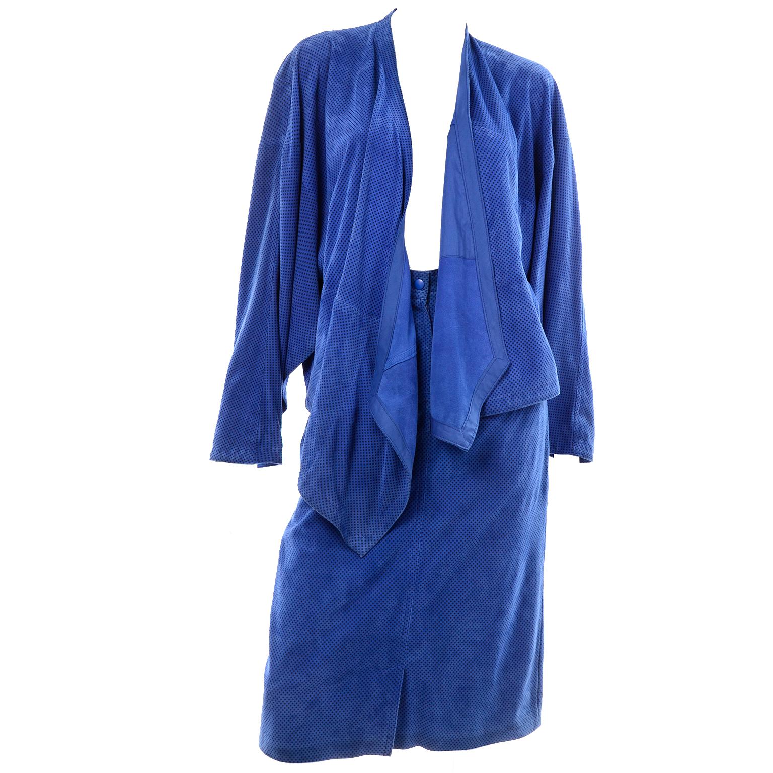 Il s'agit d'un superbe ensemble deux pièces conçu par Margaretha Ley pour Escada dans les années 1980. Le costume est en daim bleu avec de petits pois noirs et comprend une jupe et une veste enveloppante ouverte sur le devant avec des poches. La