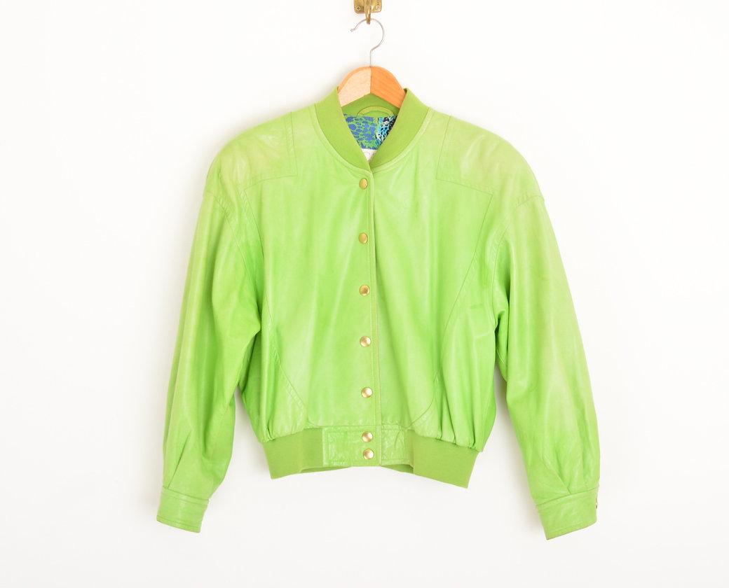 A 1980's lime green Lamskin leather bomber jacket by Escada. Fully lined with a flamboyant leopard print Silk.
 
Features;
Gently elasticated collar & waist
Gold tone central line press stud fasten
Slightly cropped length
100% Lambskin
 
Sizing;
Pit