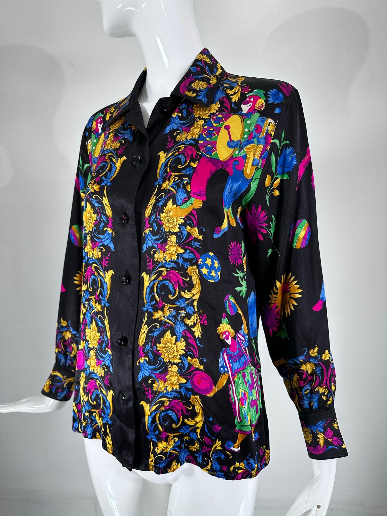 Margaretha Ley for Escada rare blouse de collection en soie imprimée avec des clowns des années 1990. Soie noire imprimée de couleurs vives et d'un assortiment de clowns joyeux faisant des trucs de clowns ! Le recto est orné de bordures classiques