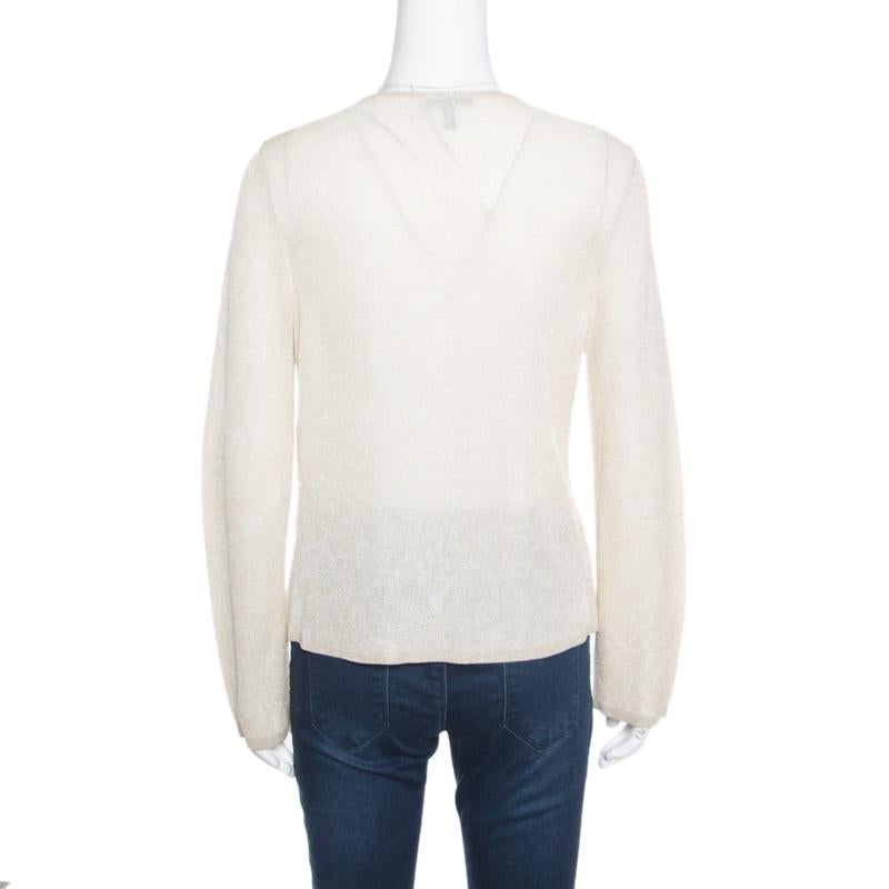 This fabulous cardigan from Escada is what your wardrobe has been missing all along! The beige creation is made of a viscose blend and features a simple knit design. It flaunts an embellished front with hook closures and come with a scooped necklne