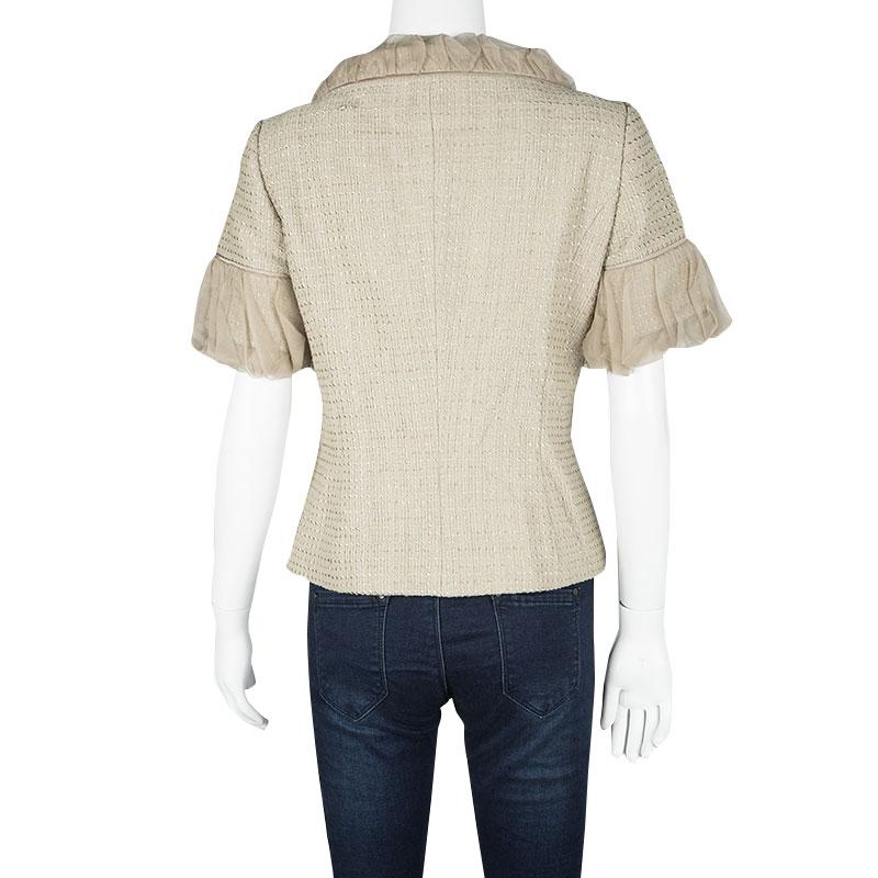 Tailored in a beige textured silk body, this Escada jacket is sure to make a statement. It features a concealed button front style with trims along the short sleeves and neckline. It comes with a rounded neckline and can be styled with a basic tee