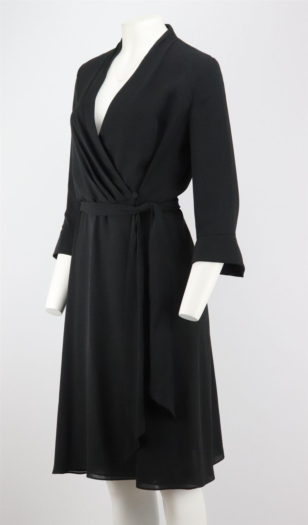 This dress by Escada is cut from silk in a wrap silhouette complete with a plunging v-neck collar and belt fastening with slightly puffed sleeves. Black silk. Button and belt fastening at front. 100% Silk; lining: 100% silk. Size: DE 38 (UK 12, US