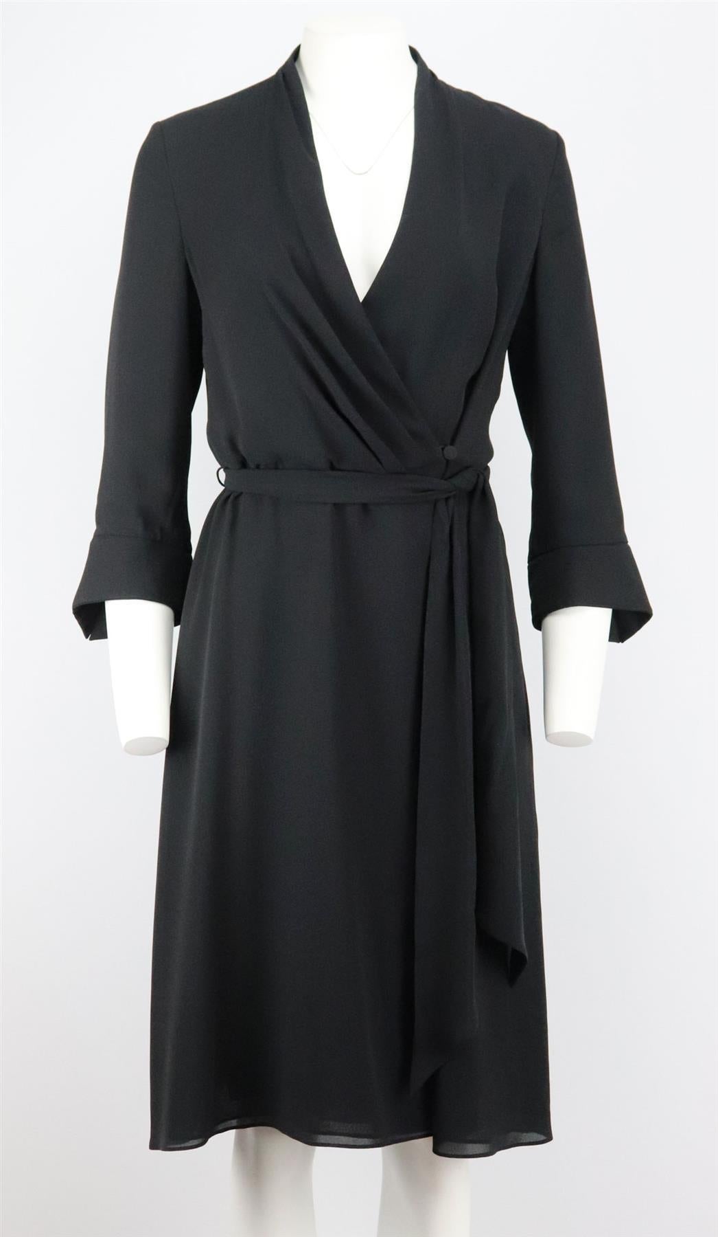 This dress by Escada is cut from silk in a wrap silhouette complete with a plunging v-neck collar and belt fastening with slightly puffed sleeves. 
Black silk. 
Button and belt fastening at front. 
100% Silk; lining: 100% silk. 

Size: DE 38 (UK 12,