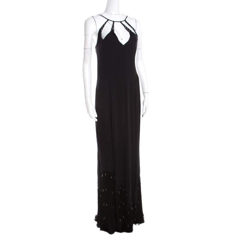 This evening dress by Escada flaunts elegance with its mesmerizing appeal and brilliant design. Tailored from smooth black silk, it comes with beautiful embellishments on the fabulous neckline and bottom. The creation has a great fit with a low cut