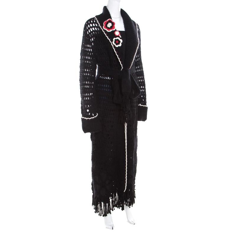 This lovely cardigan is designed by Escada in a combination of fine fabrics. It features a multicolor floral applique and a belt tie-up at the front. Designed with long sleeves, the black creation comes with scalloped detailing and tassel edge. It