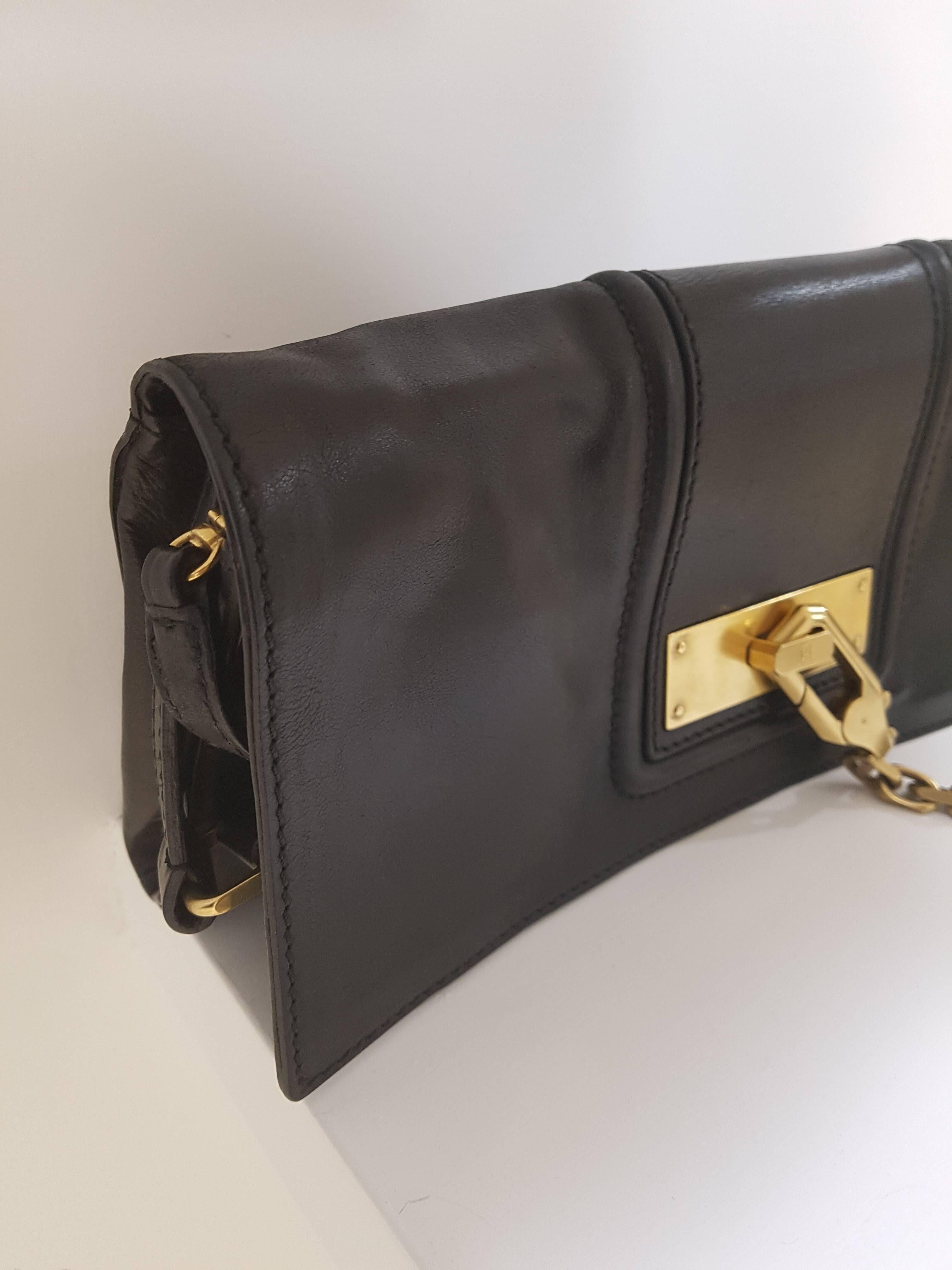 Escada Black Leather Bag

with gold tone chain and lock 
in the inside long black leather shoulder strap

can be worn as a clutch or as a shoulder bag