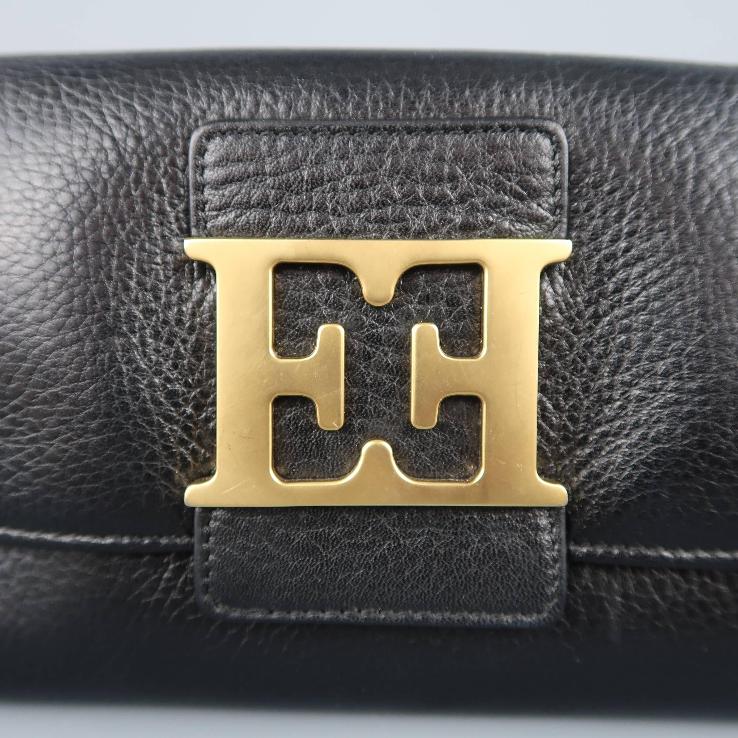 
ESCADA wallet comes in black textured leather with a flap snap closure adorned with an oversized matte gold tone double E logo, internal zip pocket, and multiple compartments. Made in Italy. Good Pre-Owned Condition.
 
Measurements:
Length: 7.25