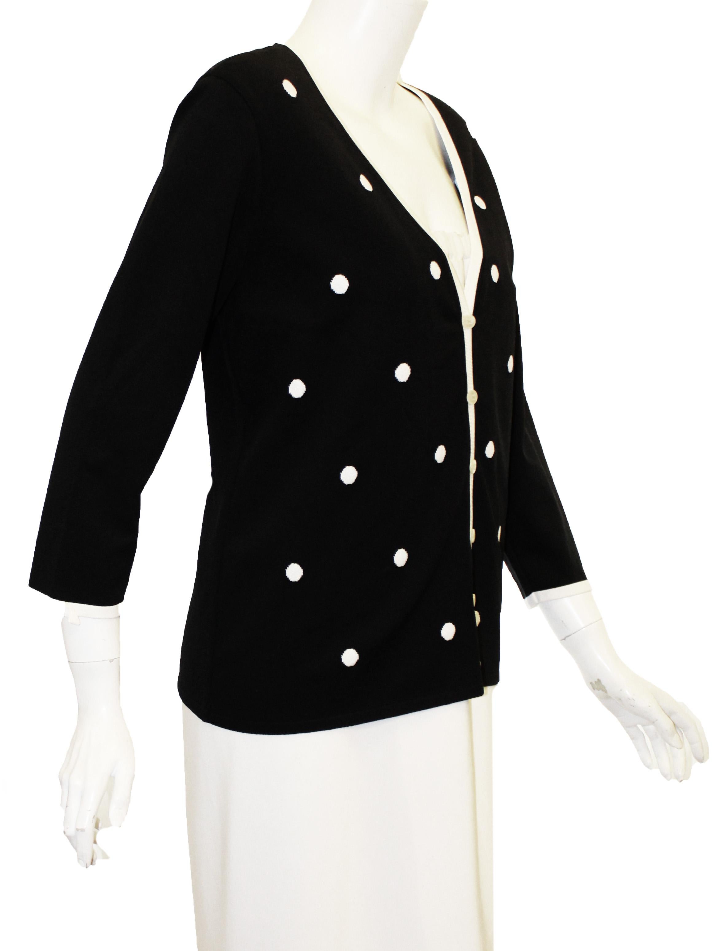 Escada black and white cardigan with white polka dots at front of jacket includes six Escada logo buttons for front closure.  This V neck cardigan has a white trim along the neckline and border of 3/4 sleeves.  This jacket is not lined.  Jacket in