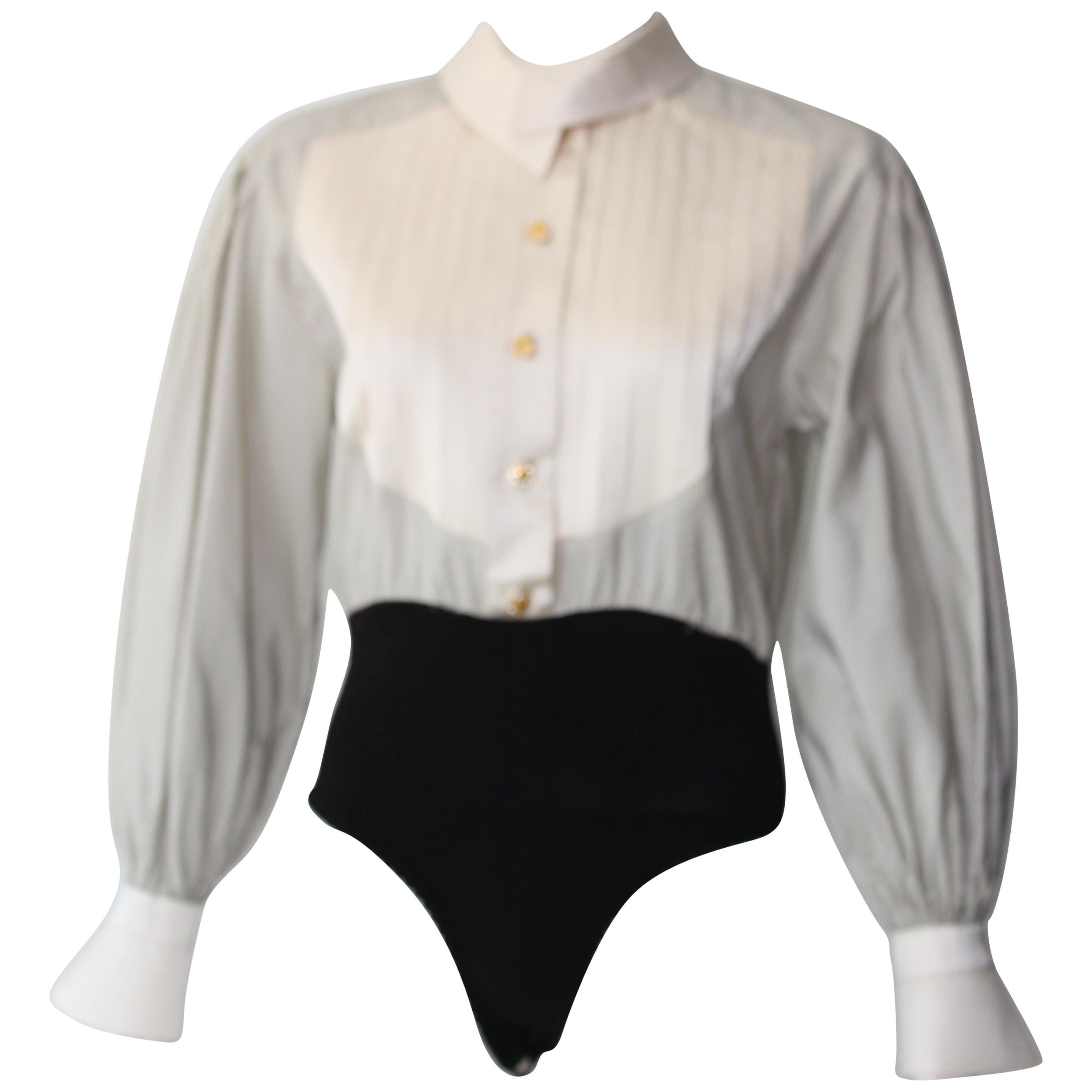 90s Vintage Escada Tuxedo Body Suit Vintage. 
Details include, Pinstripe arms and pleated satin bodice. Top fits like a dress shirt that is tucked in with billowy sleeves and bodice. 

Gold rhinestone encrusted buttons. Detachable bowtie with cotton