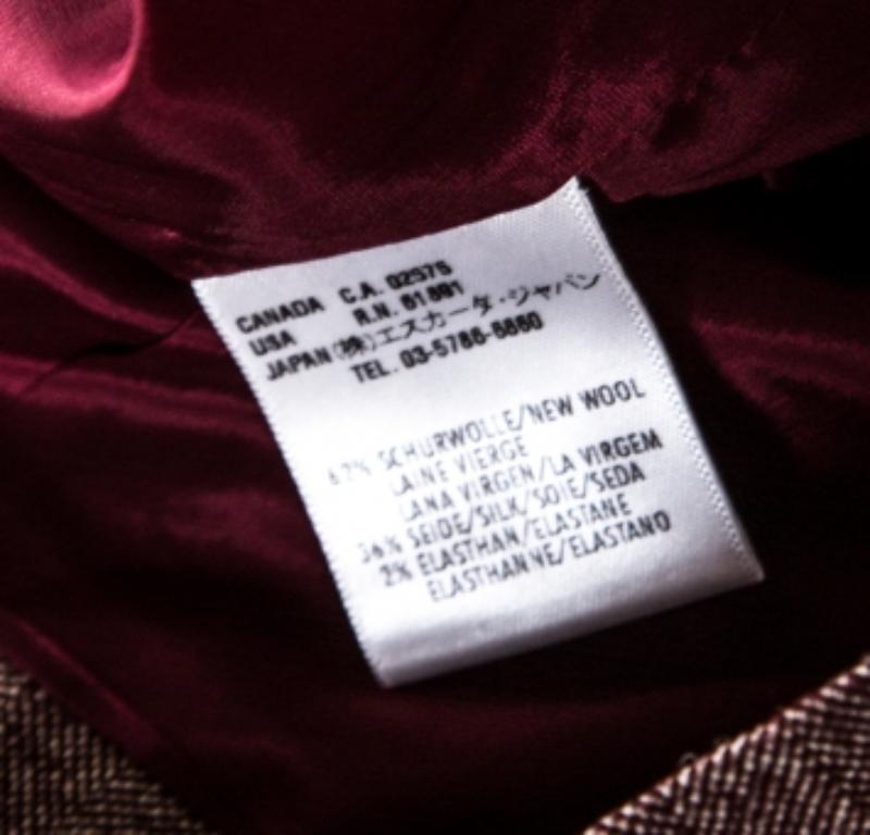 Regalati questa splendida gonna di Escada. La gonna, realizzata in lana e seta con motivi a spina di pesce, ha una chiusura a zip e una cintura in pelle a nastro. È ideale da indossare con una camicetta rimboccata e delle décolleté.