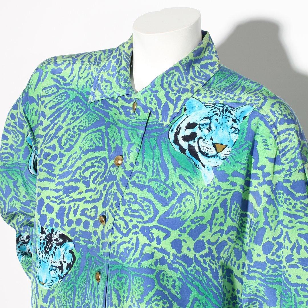 Cheetah print blouse by Escada
Circa 1980's 
Cheetah print with Cheetah heads throughout 
Long-sleeve top
Blue and green 
Button-front closures
Pointed collar
Button cuff closures
Gold-tone hardware 
100% silk
Made in Italy
Condition: Excellent,