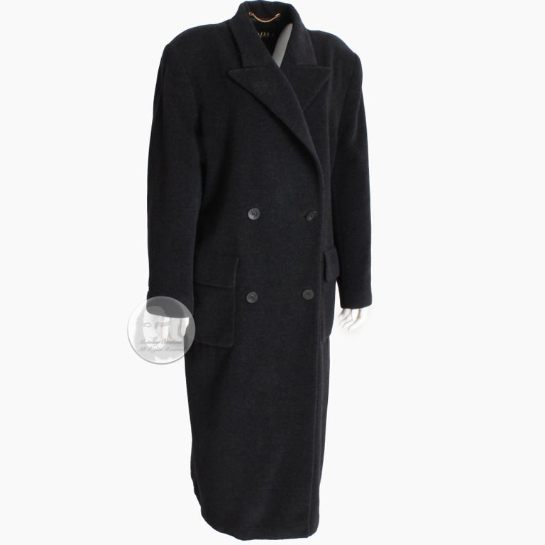 Authentic, preowned, vintage Escada coat, likely made in the 90s. Made from 100% Pure New Wool in a charcoal gray hue, it features double-breasted construction with flap pockets at each hip and a faux belt in back.   

An iconic style and