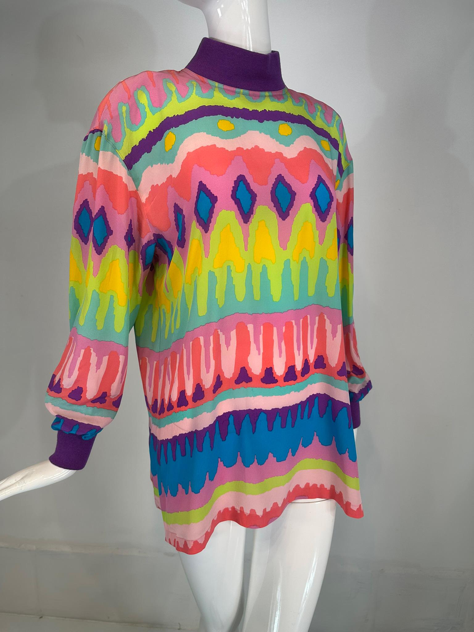 Escada colourful silk crepe wavy stripe pull on tunic with knit collar & cuffs from the 1980s. Bright wavy stripes in interesting shapes splash across the front & back & sleeves of this tunic. The neck & cuffs are done in purple knit. The tunic