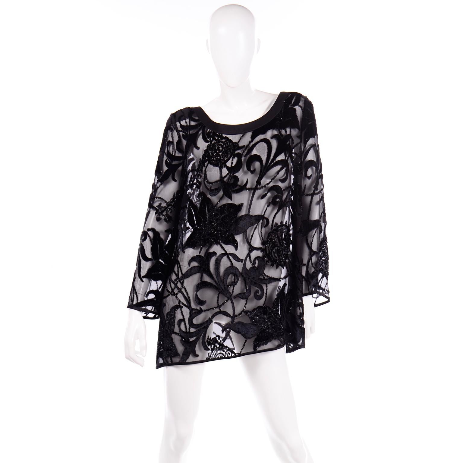 This is an elegant Escada Couture black silk tunic top with sparkly velvet burnout floral pattern throughout. This blouse has a boat neckline that is lined in black silk and the rest of the blouse is sheer and unlined.  There are shoulder pads for