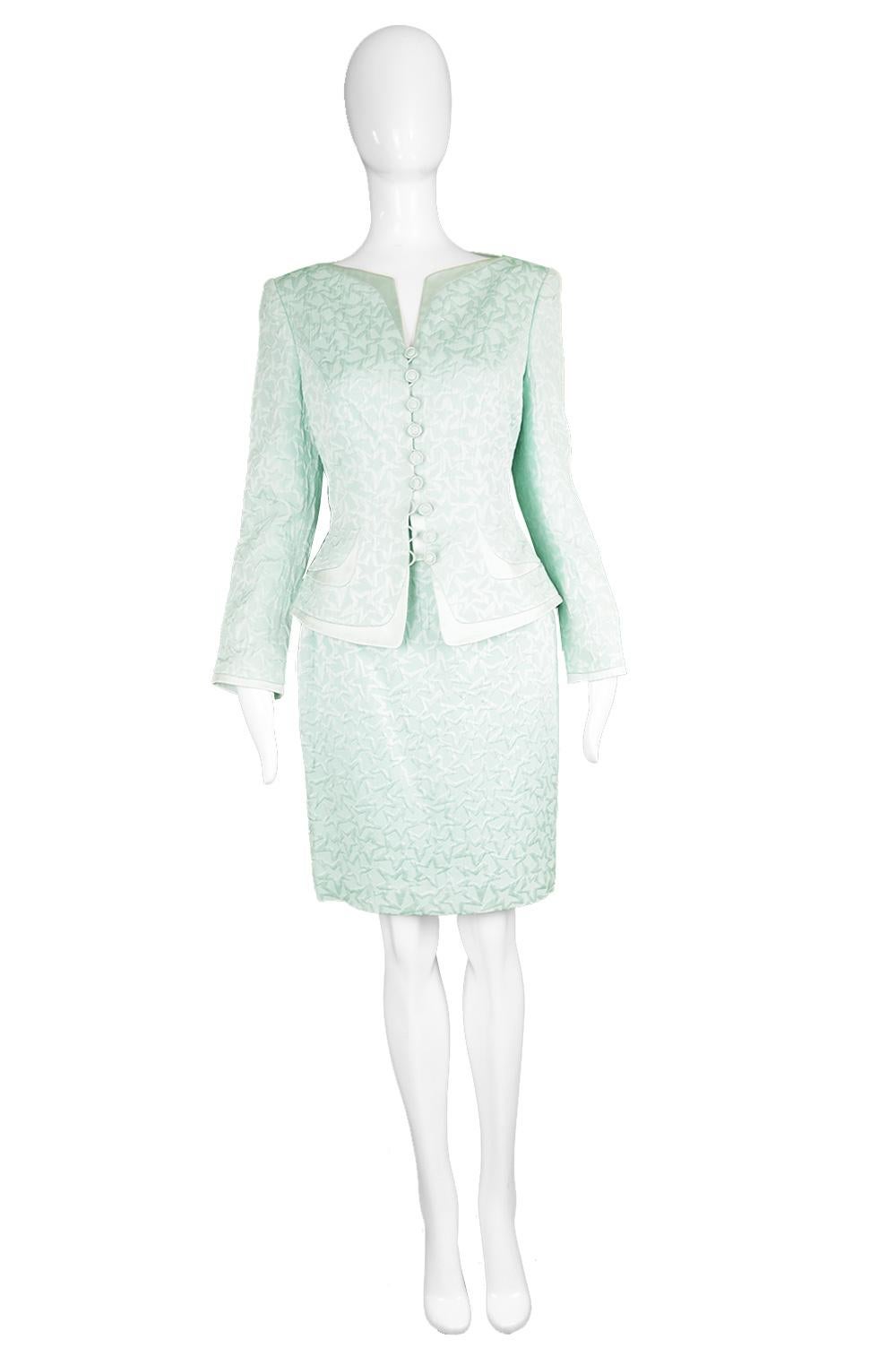 A fabulous vintage women's two piece skirt and jacket ensemble from the 90s by luxury German fashion house, Escada for their Couture line. In a lightweight, mint / aqua cotton and silk blend brocade, creating a star pattern throughout with a silk