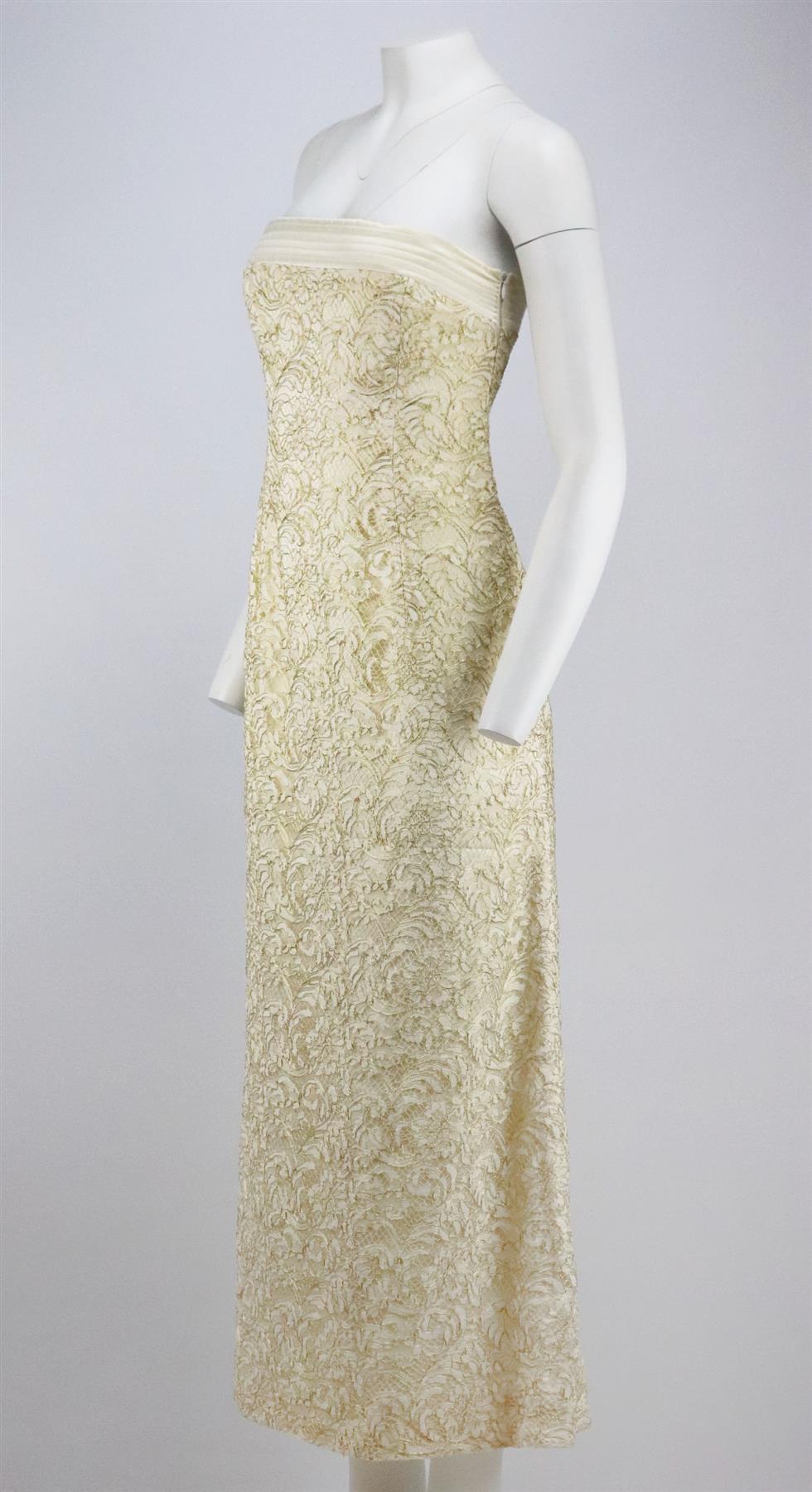 Este vestido vintage de Escada Couture está confeccionado en encaje marfil con detalles de cordones dorados y adornos de satén a lo largo del escote sin tirantes, cae hasta el tobillo en una silueta entallada. Encaje marfil y dorado, satén marfil.