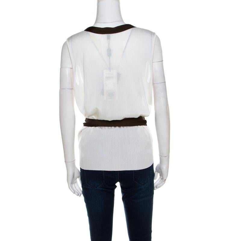In a wardrobe of basics, this Escada top will a breath of fresh air with its bold new design. This cream piece makes a remarkable statement no matter where you wear it to. Made in a sleeveless style with contrasting tie up trims, this top will look