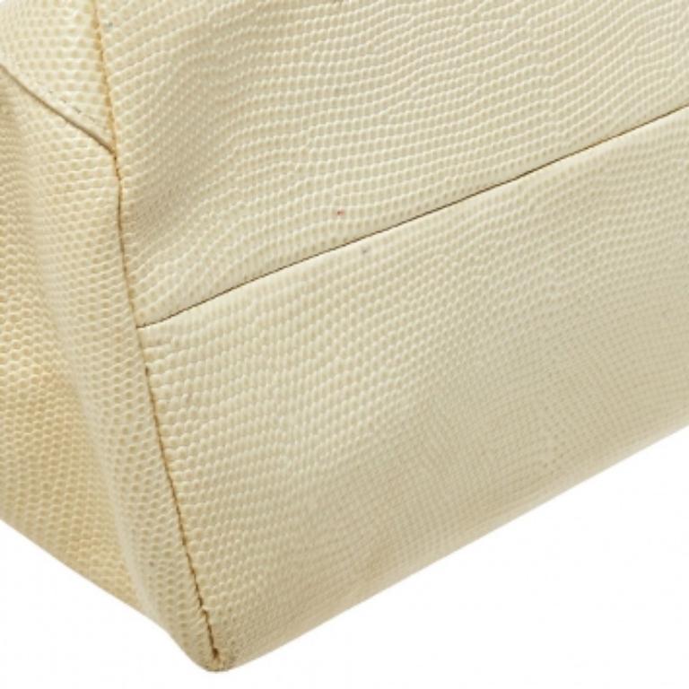 Fabriqué en Italie, ce magnifique sac d'Escada brille par sa beauté. Confectionné en cuir embossé de lézard, il arbore le logo de la marque sur le devant et s'ouvre sur un compartiment en tissu. Doté d'une poignée unique, vous méritez vraiment