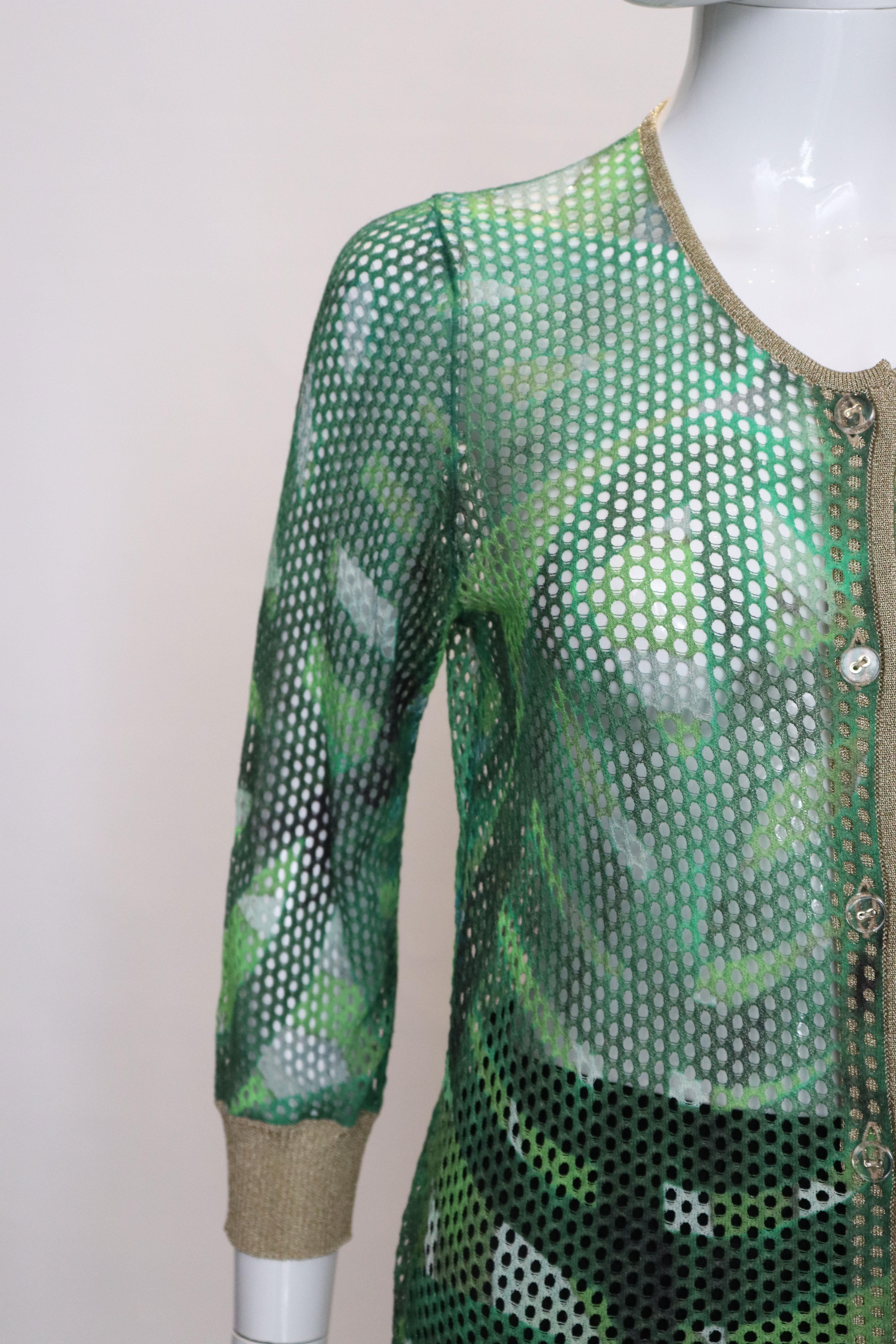 A chic green mesh and gold cardigan. The green mesh has an attractive  print. 