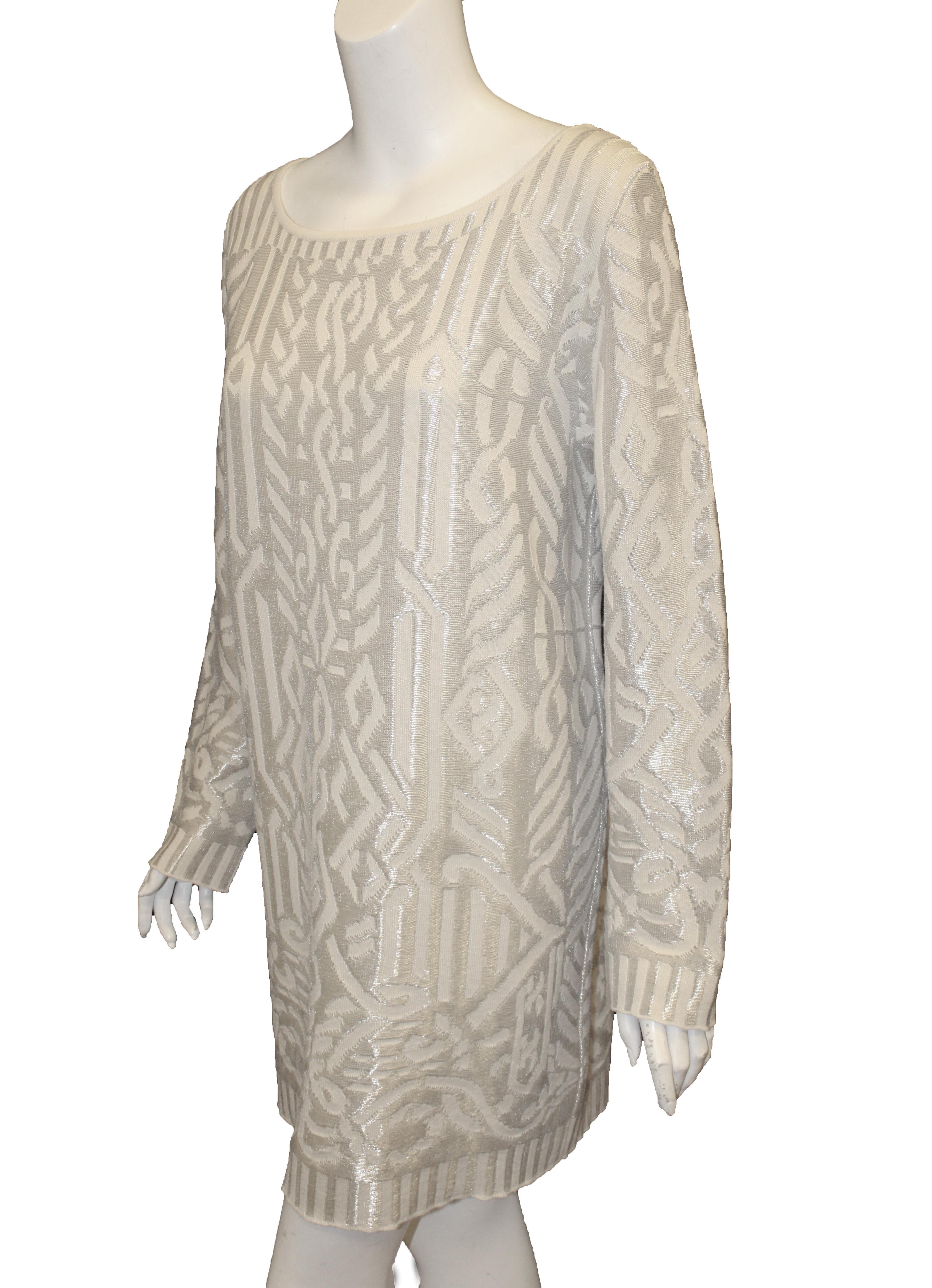 Escada ivory pullover tunic top is embroidered with silver tone metallic threads throughout creating an abstract design that intertwines with the ivory wool knit.   This long sleeve scoop neck, relaxed fit sweater can be worn as a long sweater over