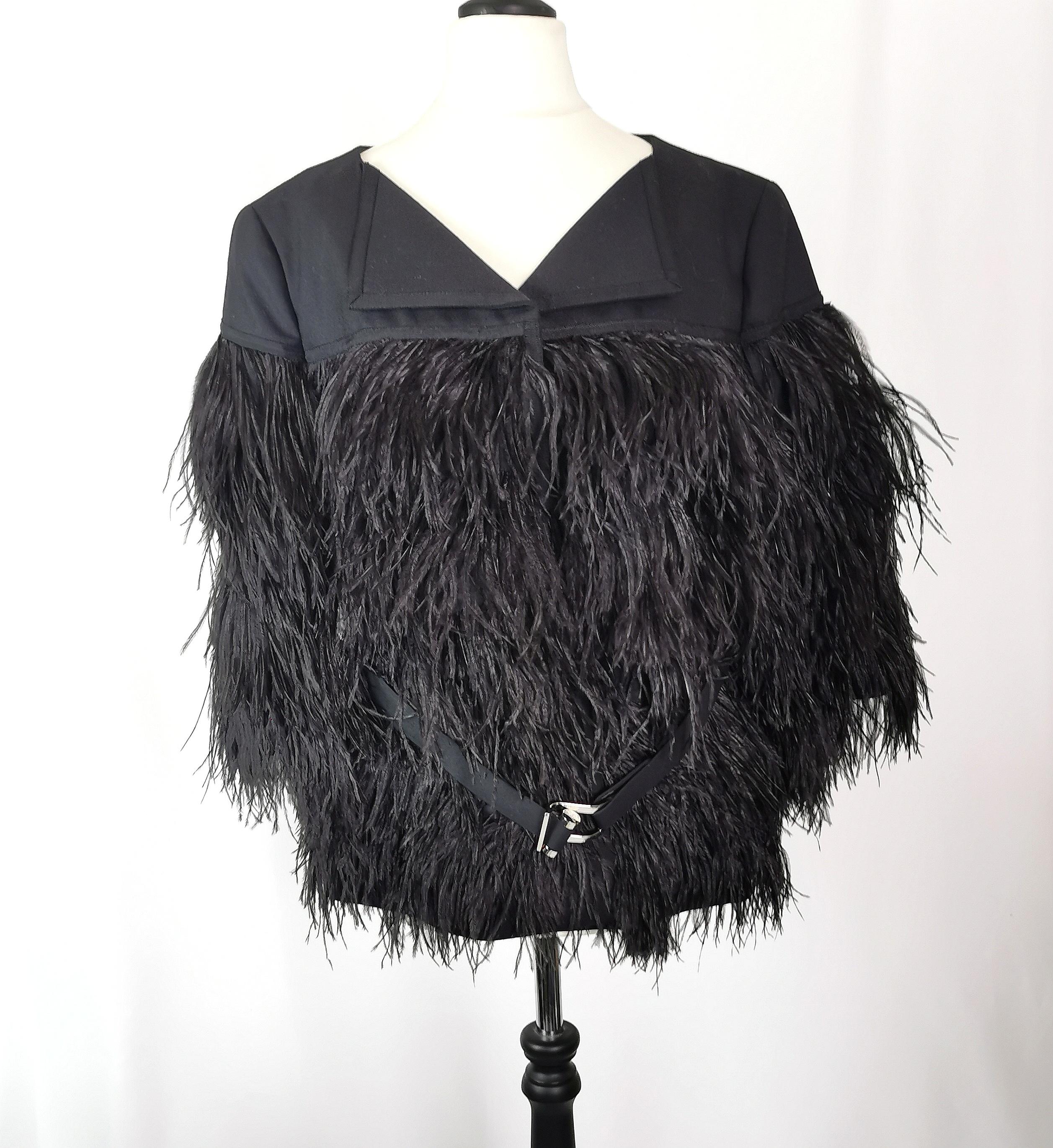 A gorgeous Escada ladies Black ostrich feather jacket.

The jacket is a boxy shape made from black woven mixed blend fabric, plain to the top half, shoulders and neck and covered all over with lush soft inky Black ostrich feathers all the way