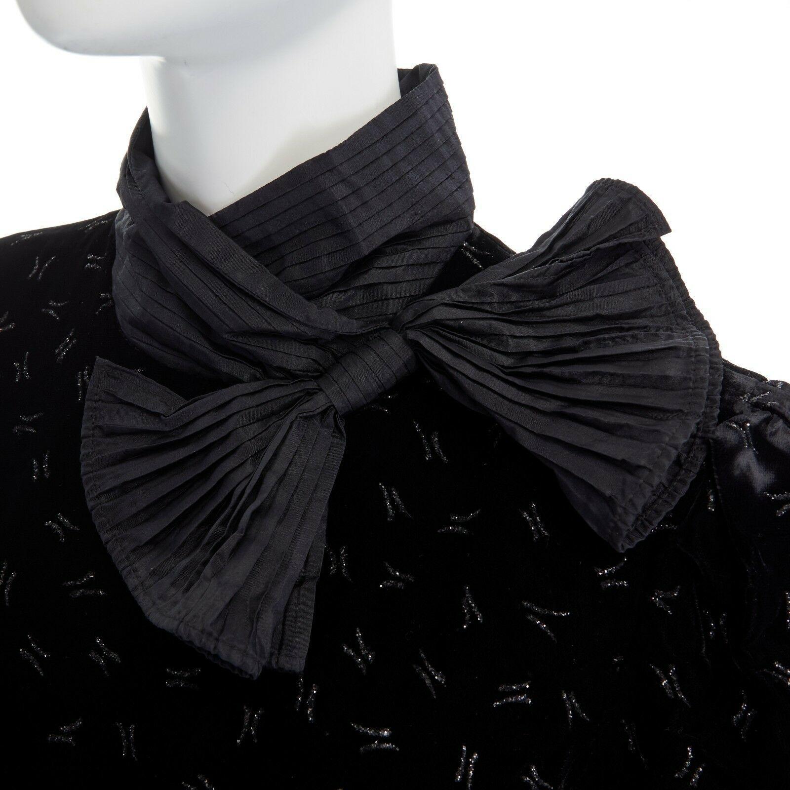 ESCADA MARGARETHA LEY 1980's embroidered velvet pleated box ruffle hem dress M
ESCADA BY MARGARETHA LEY
Rayon, silk, acetate. 
Black velvet. Metlalic glitter print. 
Pleated bow detail at neck. 
High collar. 
Padded puff shoulder. 
3/4 sleeves.