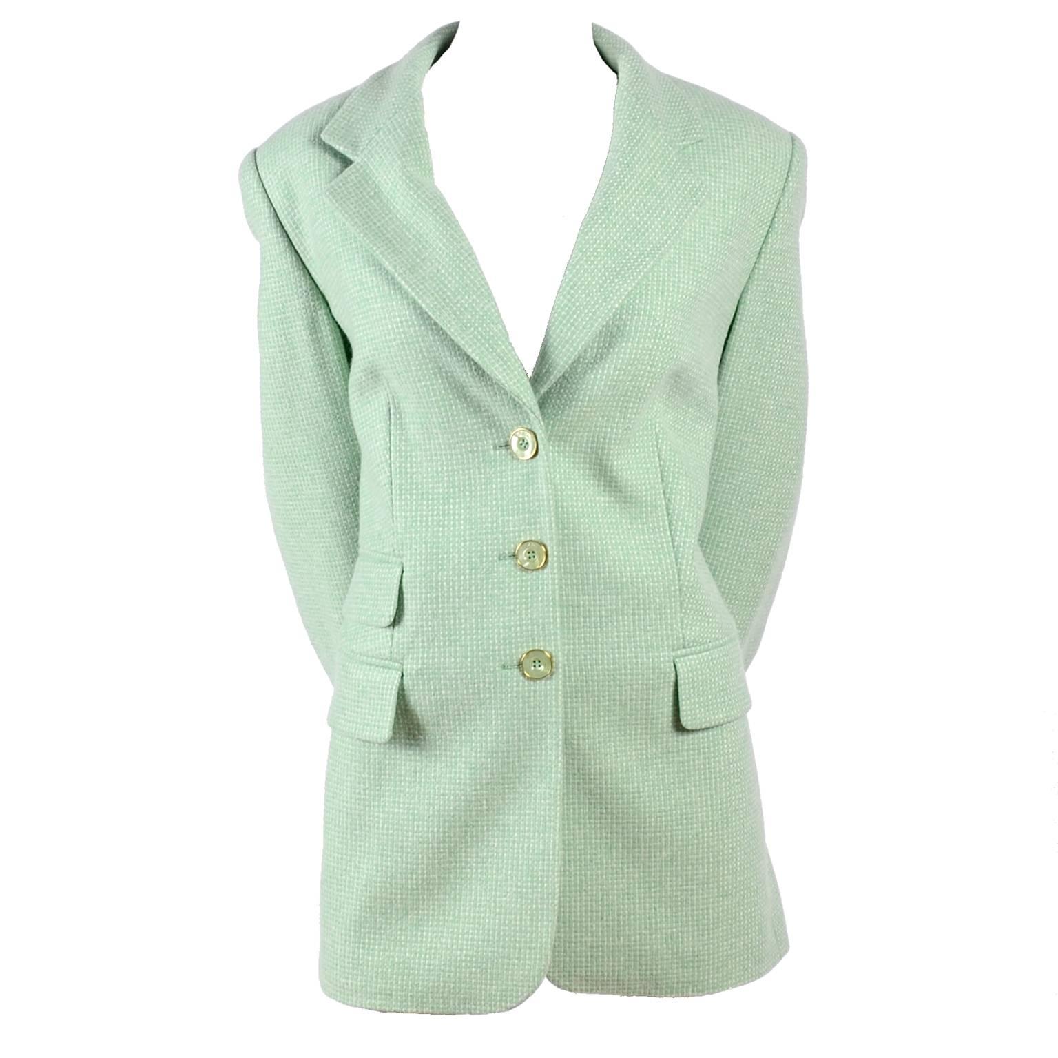 This vintage Escada blazer was designed by Margaretha Ley and is made of 100% cashmere and lined in Escada logo printed green rayon satin. The jacket has 3 Escada marked buttons on the front and 3 of the same green and gold logo buttons on each