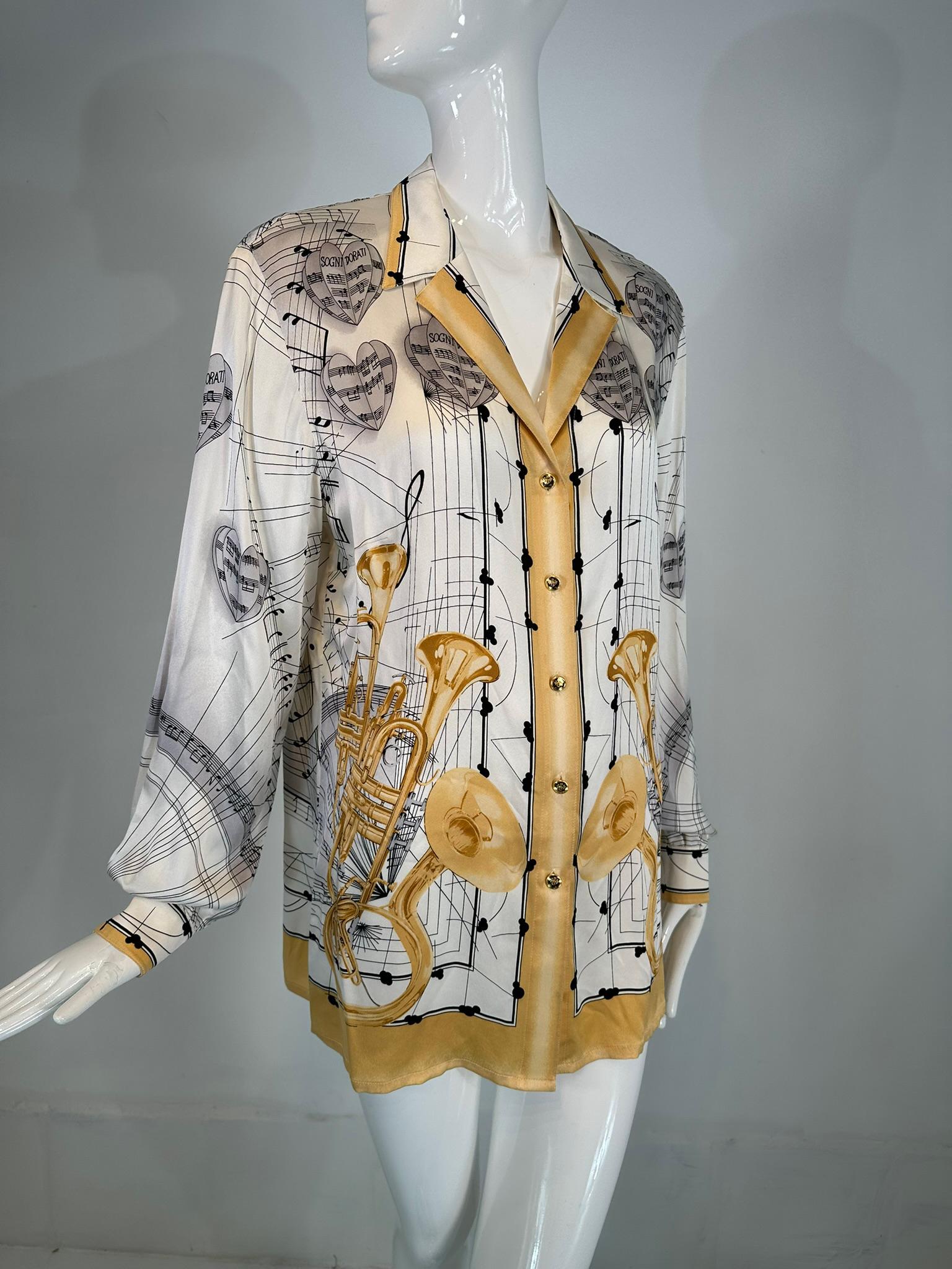 Escada Margaretha Ley musical theme silk print blouse from the 1980s, marked size 42. Notched wing collar blouse with gold button front, long sleeves with button cuffs and finished hem. This blouse design features musical instruments and sheet music
