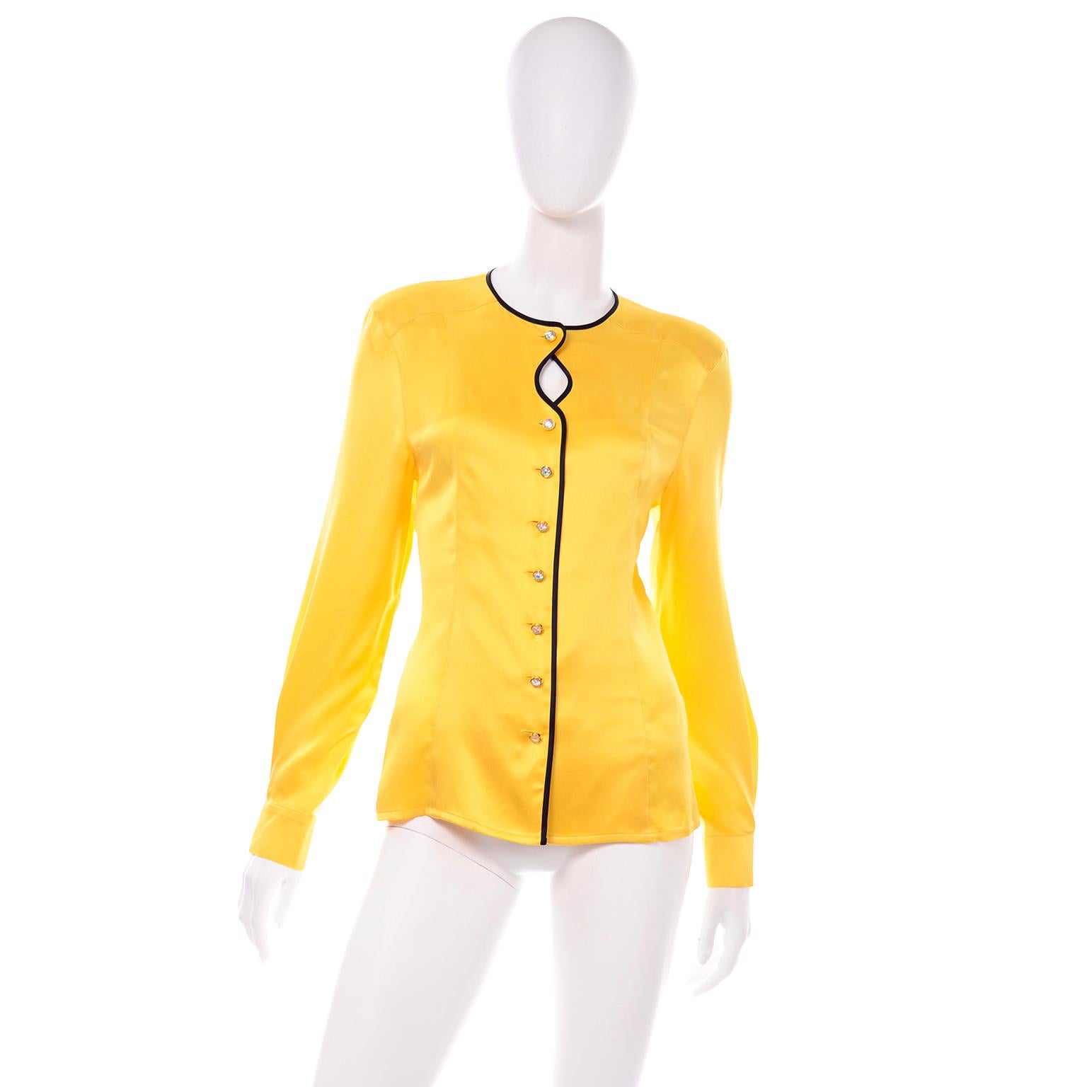 This unique golden yellow silk blouse by Escada is really beautiful, and it is made with the care to detail you would expect from the vintage Margaretha Ley Escada pieces.The buttons are beautiful iridescent gems in gold tone monogrammed settings.