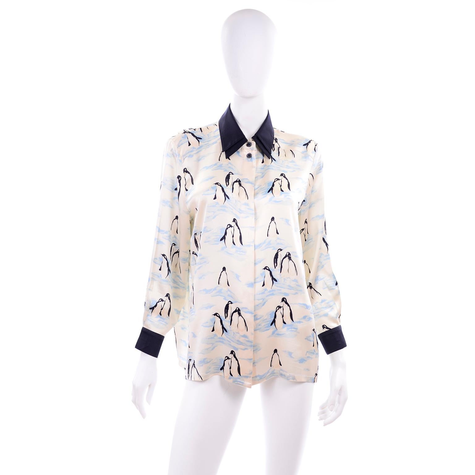 Margaretha Ley designed this penguin novelty print silk blouse for Escada in the 1980's. The blouse is ivory with abstract blue ice and black and white penguins.  The double collar and cuffs are in midnight navy blue and the blouse buttons up the