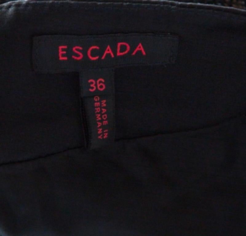 Questa gonna di Escada ti darà un look semplice ma alla moda. È disponibile in nero metallizzato con finiture satinate. Se ami abbracciare la moda classica, questa gonna è perfetta per te.