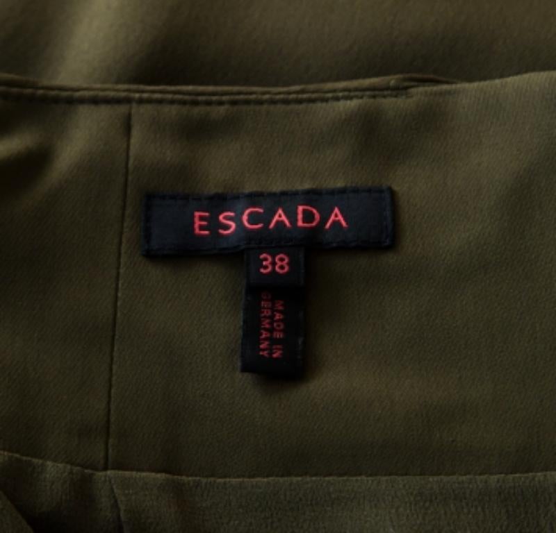 Puoi aggiungere questa gonna Escada di gran classe al tuo guardaroba per un tocco di freschezza. Dai un tocco di classe al tuo stile quotidiano in ufficio con questa incantevole gonna verde muschio in seta con arricciatura in vita.