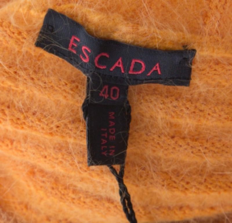 Per giornate all'insegna del calore lussuoso, Escada ti propone questo bolero di lana che è stato lavorato a maglia con una miscela di tessuti, tra cui l'angora. La creazione presenta maniche lunghe e una chiusura a bottoni sul davanti. Il Bolero è