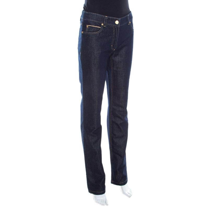 Tailored from a cotton blend, these Escada jeans are designed in a straight leg fit. This navy blue glitter denim features five external pockets, belt loops, zip closure and the brand logo on the back. These high rise bottoms will provide a great