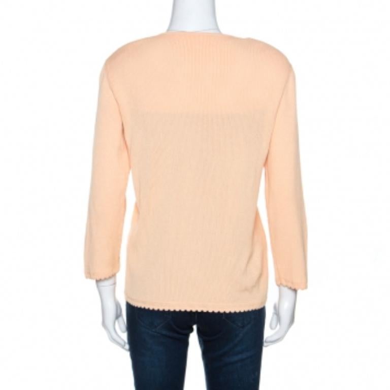 Diese schlichte und stilvolle Strickjacke von Escada ist ein guter Kauf. Es ist aus einer Baumwollmischung gefertigt und hat eine schöne pfirsichfarbene Farbe. Diese Kreation aus Rippstrick hat eine Knopfleiste, lange Ärmel, gepolsterte Schultern