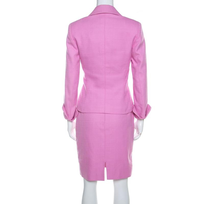 This Escada skirt suit is smart and feminine at the same time. Tailored from cotton, it features an elegant blazer and skirt. The blazer has rounded lapels, front buttons, and two pockets. Its skirt has a fine fitting as well as a vent at the