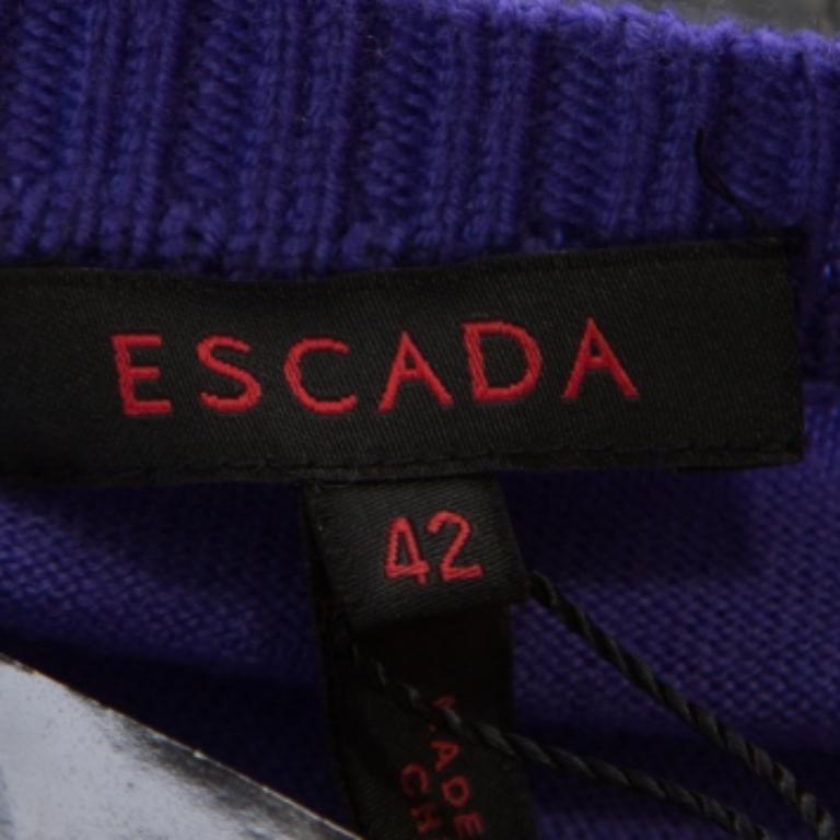Escada ci delizia con questo meraviglioso cardigan viola. È realizzato in lana e mohair e presenta bottoni frontali e dettagli a volant sulle maniche lunghe. Il cardigan sarà un'aggiunta deliziosa al tuo armadio.