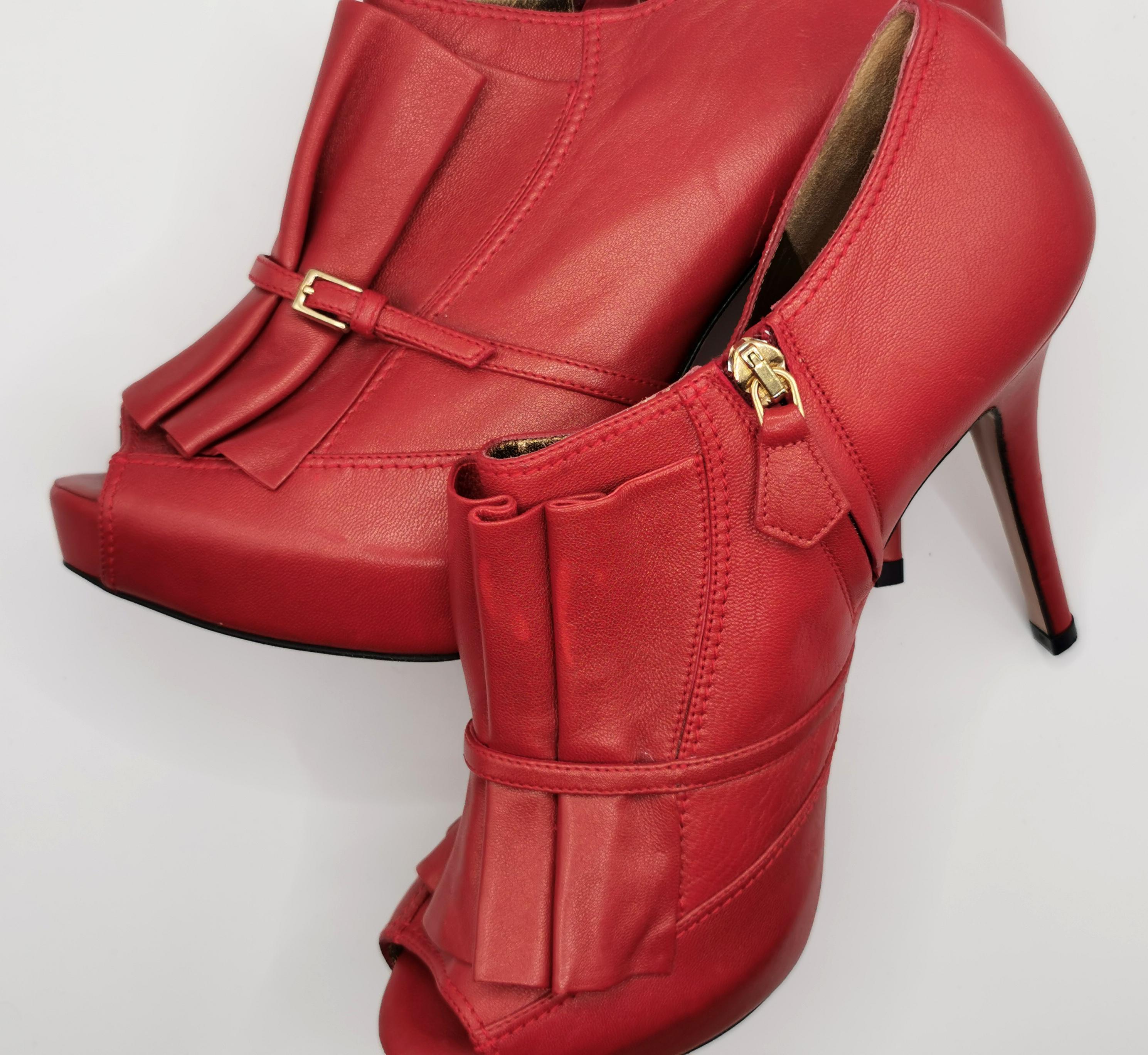 A gorgeous pair of Escada red leather peep toe heeled shoes.

These are high heeled shoes with full coverage apart from the peep toe, they feature a lovely folded pleat design to the leather front with a small buckle detail to the side.

Bronze